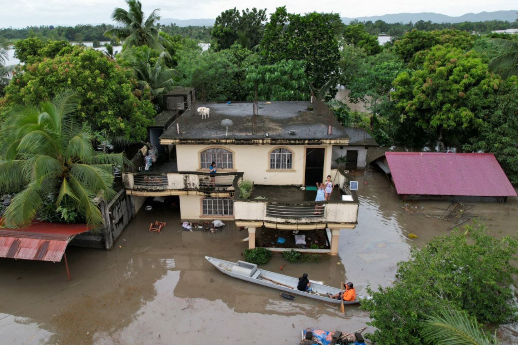 Una vista aérea muestra a un residente a bordo de un bote de madera maniobrando entre casas inundadas a causa de las fuertes lluvias provocadas por la tormenta tropical Trami en la ciudad de Bato, provincia de Camarines Sur, al sur de Manila. Foto AFP