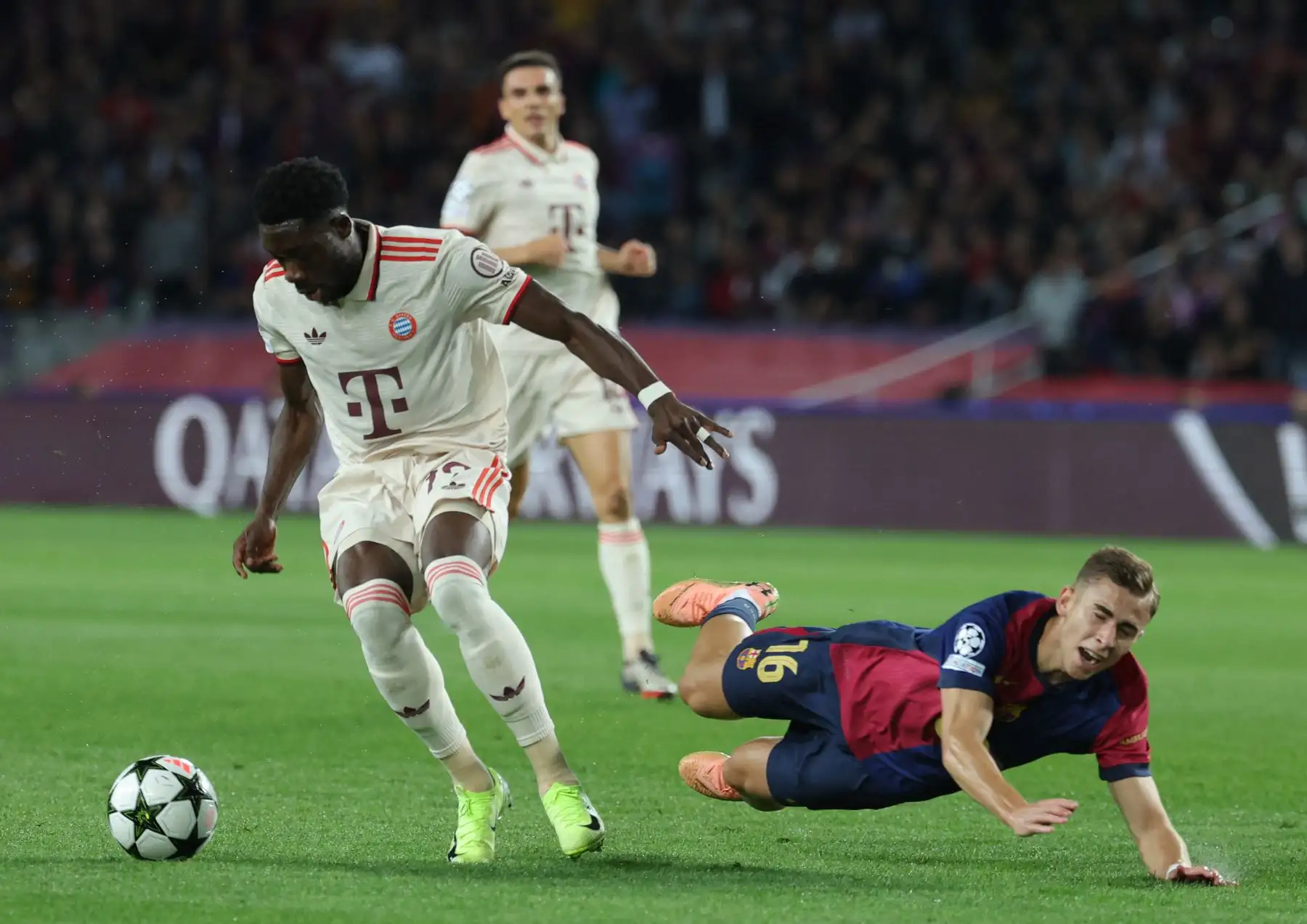 El centrocampista español del Barcelona Fermín López cae junto al defensor canadiense del Bayern Múnich Alphonso Davies durante el partido de fútbol de la jornada 3 de la fase de liga de la UEFA Champions League entre el FC Barcelona y el FC Bayern Múnich en el Estadi Olimpic Lluis Companys en Barcelona. Foto: ANDINA/AFP