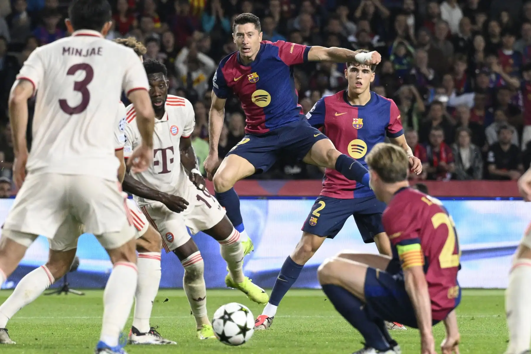 El defensa canadiense del Bayern Munich, Alphonso Davies, y el delantero polaco del Barcelona, ​​Robert Lewandowski (C), compiten por el balón durante el partido de fútbol de la jornada 3 de la fase de liga de la UEFA Champions League entre el FC Barcelona y el FC Bayern Munich en el Estadi Olimpic Lluis Companys en Barcelona. Foto. ANDINA/AFP