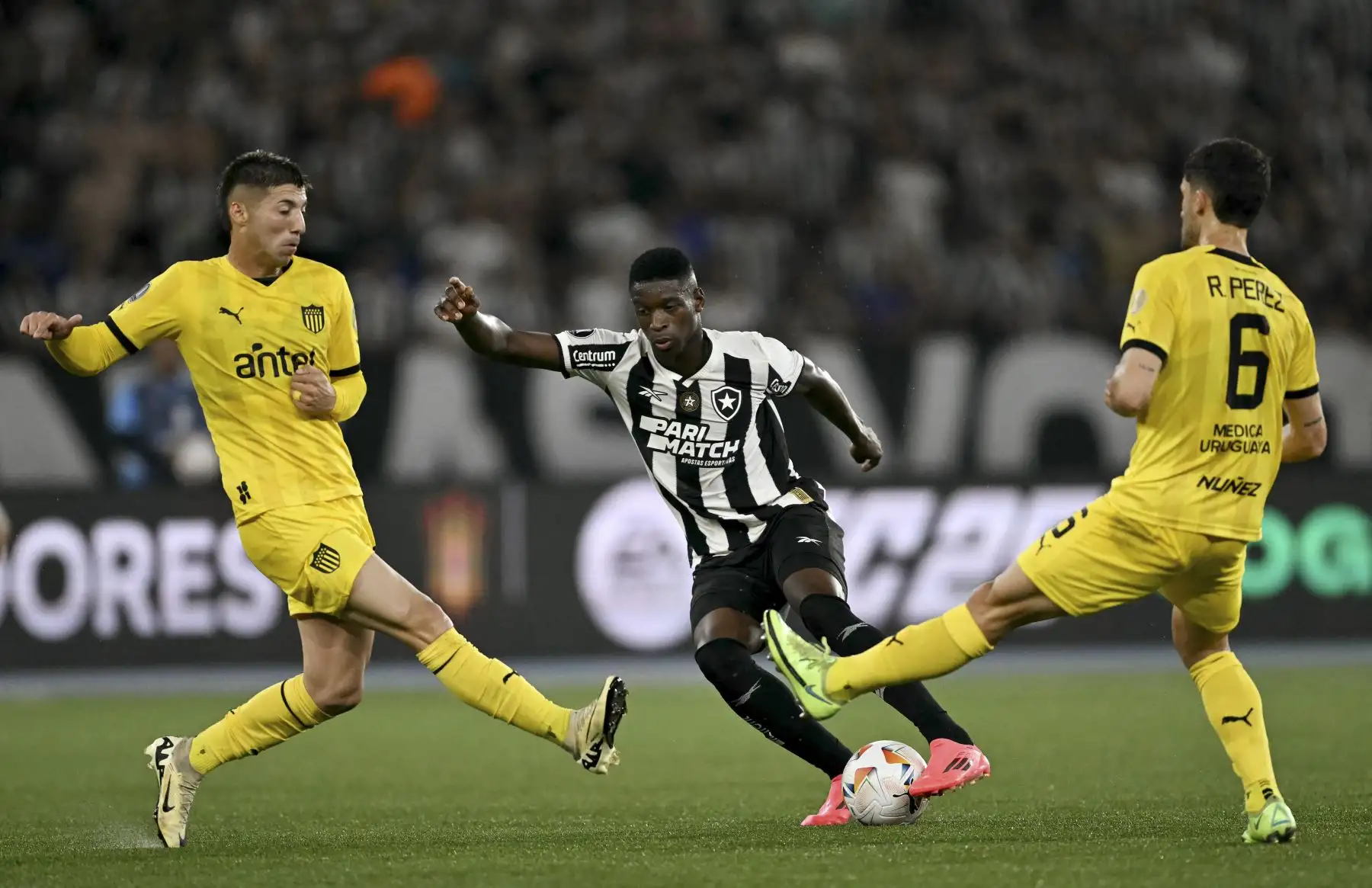 El delantero de Botafogo, Luis Henrique, lucha por el balón con el defensor argentino de Peñarol, Damián García, y el mediocampista argentino, Rodrigo Pérez, durante el partido de ida de las semifinales de la Copa Libertadores entre el Botafogo de Brasil y el Peñarol de Uruguay en el Estadio Olímpico Nilton Santos en Río de Janeiro, Brasil. Foto: ANDINA/AFP