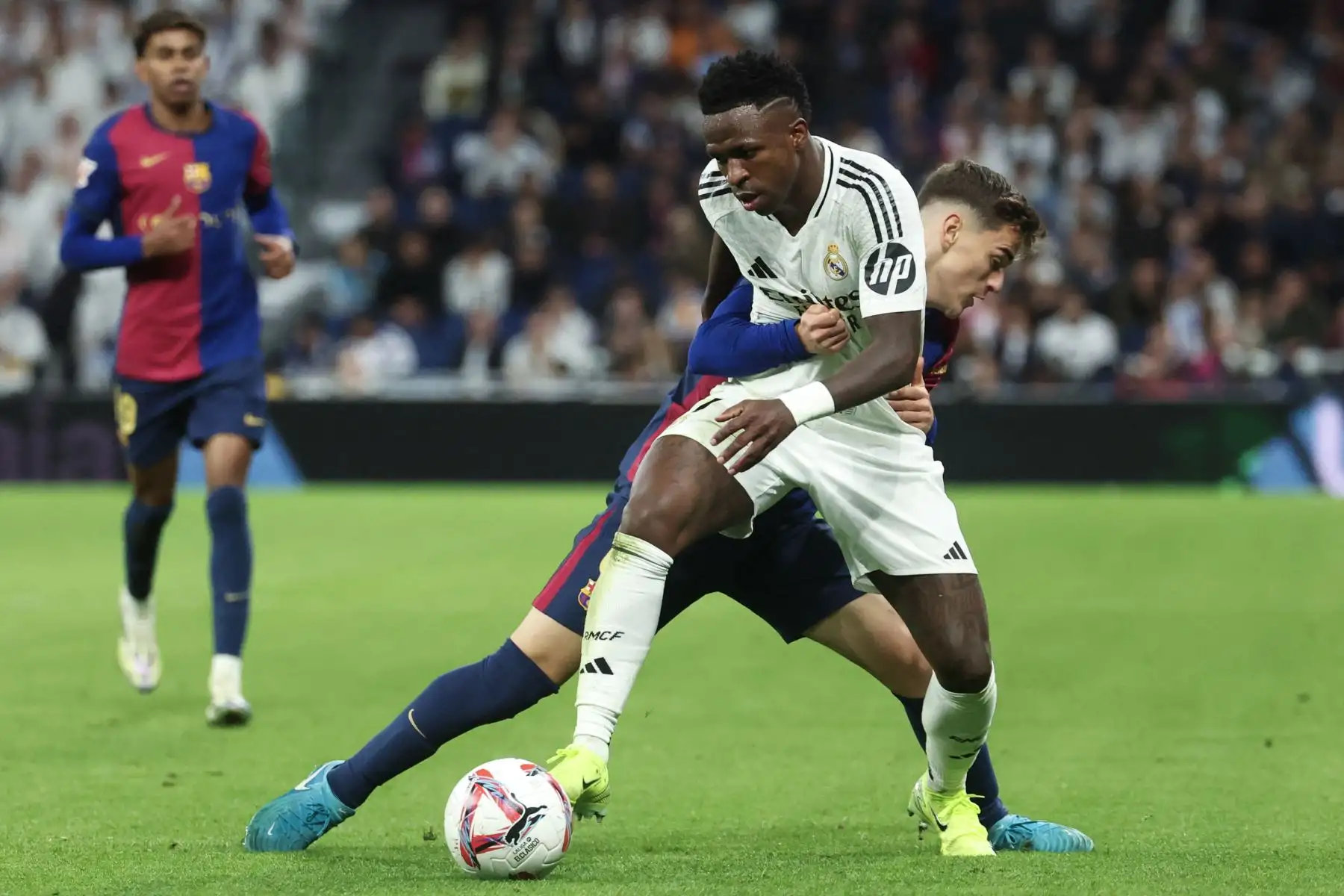 El delantero brasileño del Real Madrid Vinicius Junior es desafiado por el mediocampista español del Barcelona Pablo Gavi durante el partido de fútbol de la liga española entre el Real Madrid CF y el FC Barcelona en el estadio Santiago Bernabéu en Madrid. Foto: ANDINA/AFP