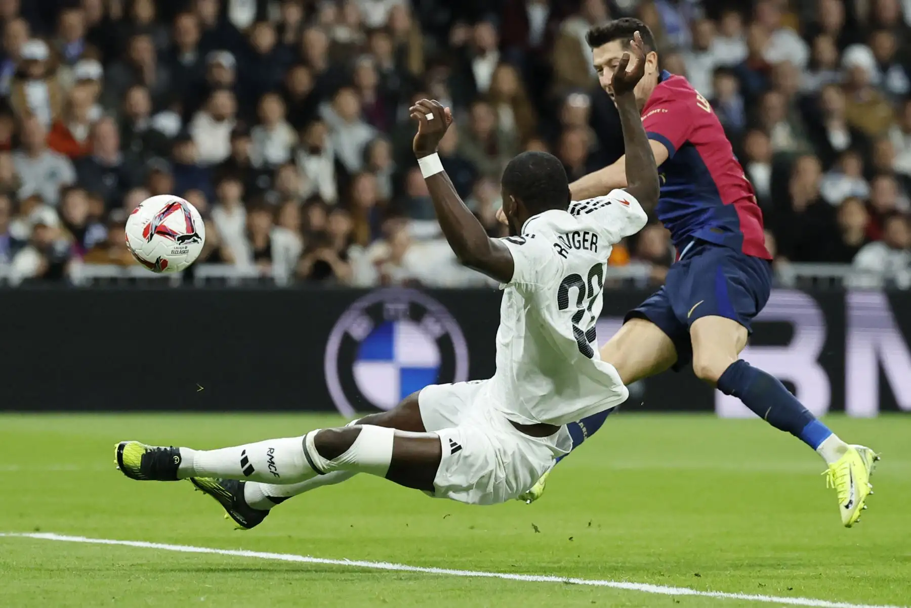 El defensa alemán del Real Madrid, Antonio Ruediger, desafía al delantero polaco del Barcelona, ​​Robert Lewandowski, durante el partido de fútbol de la liga española entre el Real Madrid CF y el FC Barcelona en el estadio Santiago Bernabéu de Madrid. Foto: ANDINA/ AFP