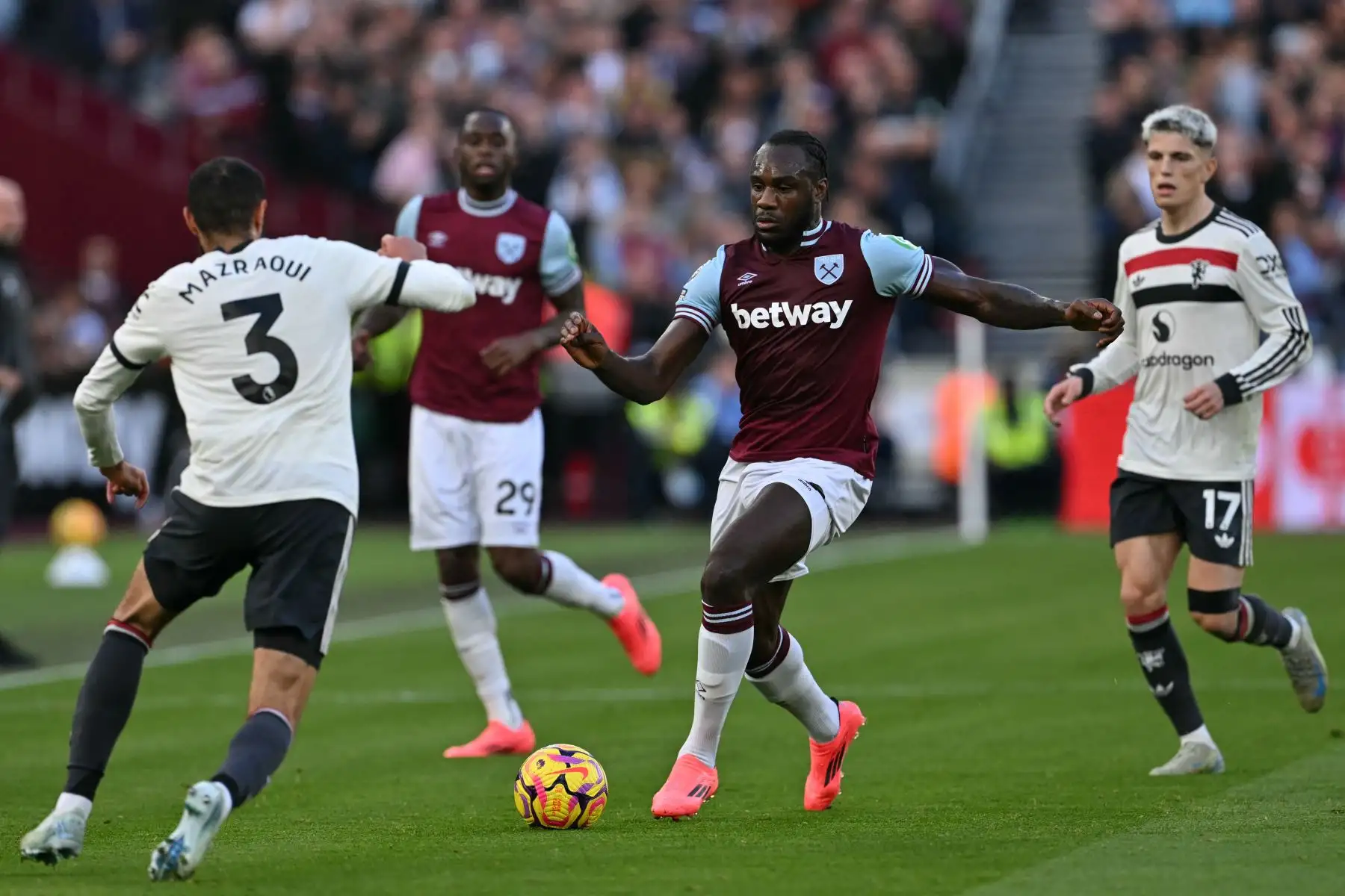 El defensor marroquí del Manchester United  Noussair Mazraoui compite con el centrocampista inglés del West Ham United  Michail Antonio durante el partido de fútbol de la Premier League inglesa entre West Ham United y Manchester United. AFP