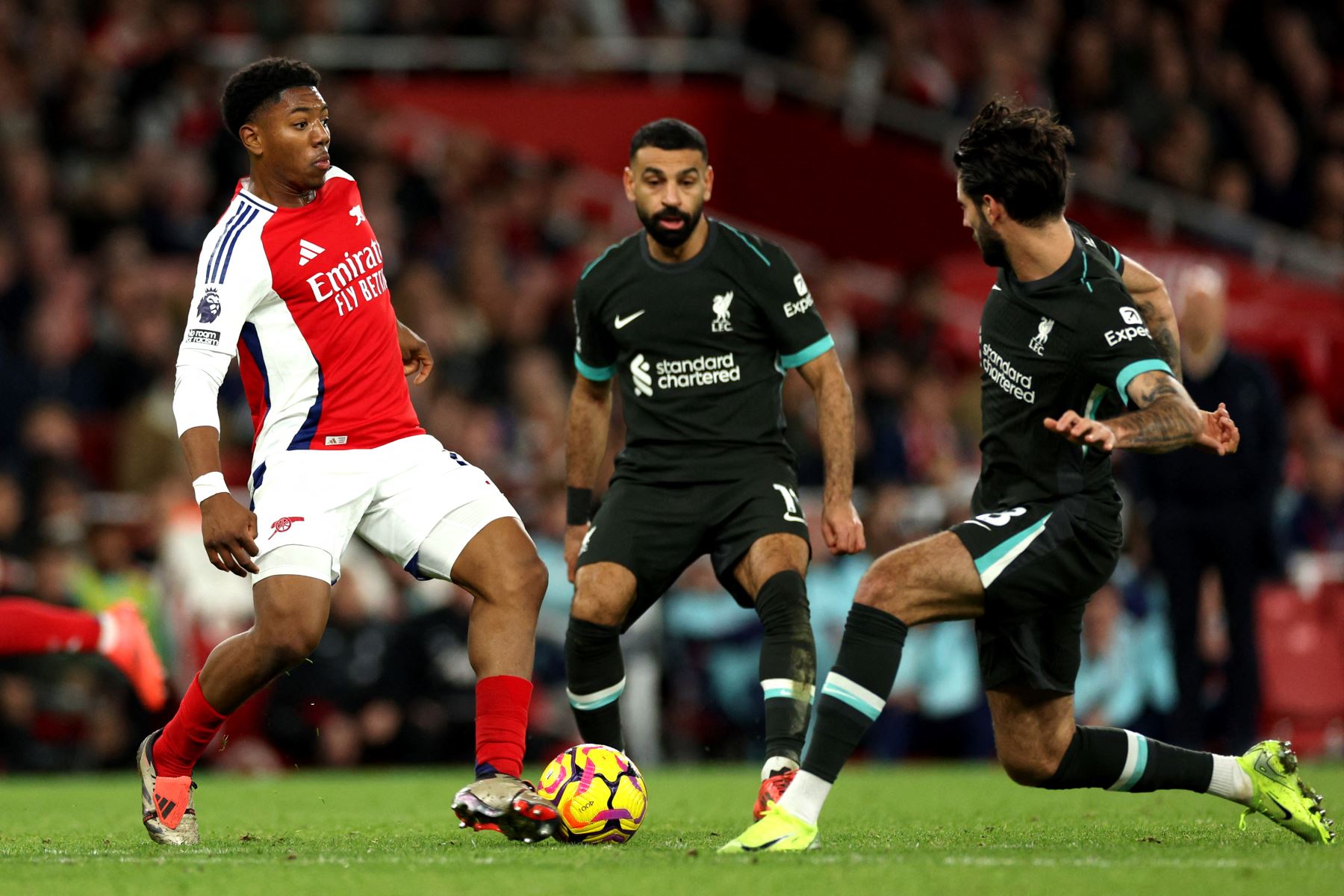 El centrocampista inglés del Arsenal Myles Lewis-Skelly compite por el balón con el centrocampista húngaro del Liverpool Dominik Szoboszlai durante el partido de fútbol de la Premier League inglesa entre el Arsenal y el Liverpool. AFP