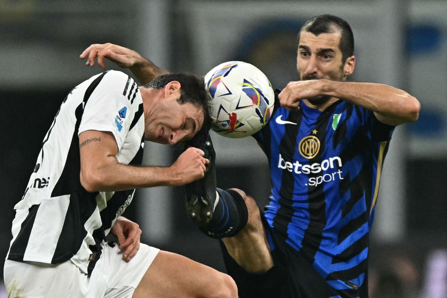 El defensor italiano de la Juventus Andrea Cambiaso lucha por el balón con el centrocampista armenio del Inter de Milán Henrikh Mkhitaryan durante el partido de fútbol de la Serie A italiana entre el Inter de Milán y la Juventus. AFP