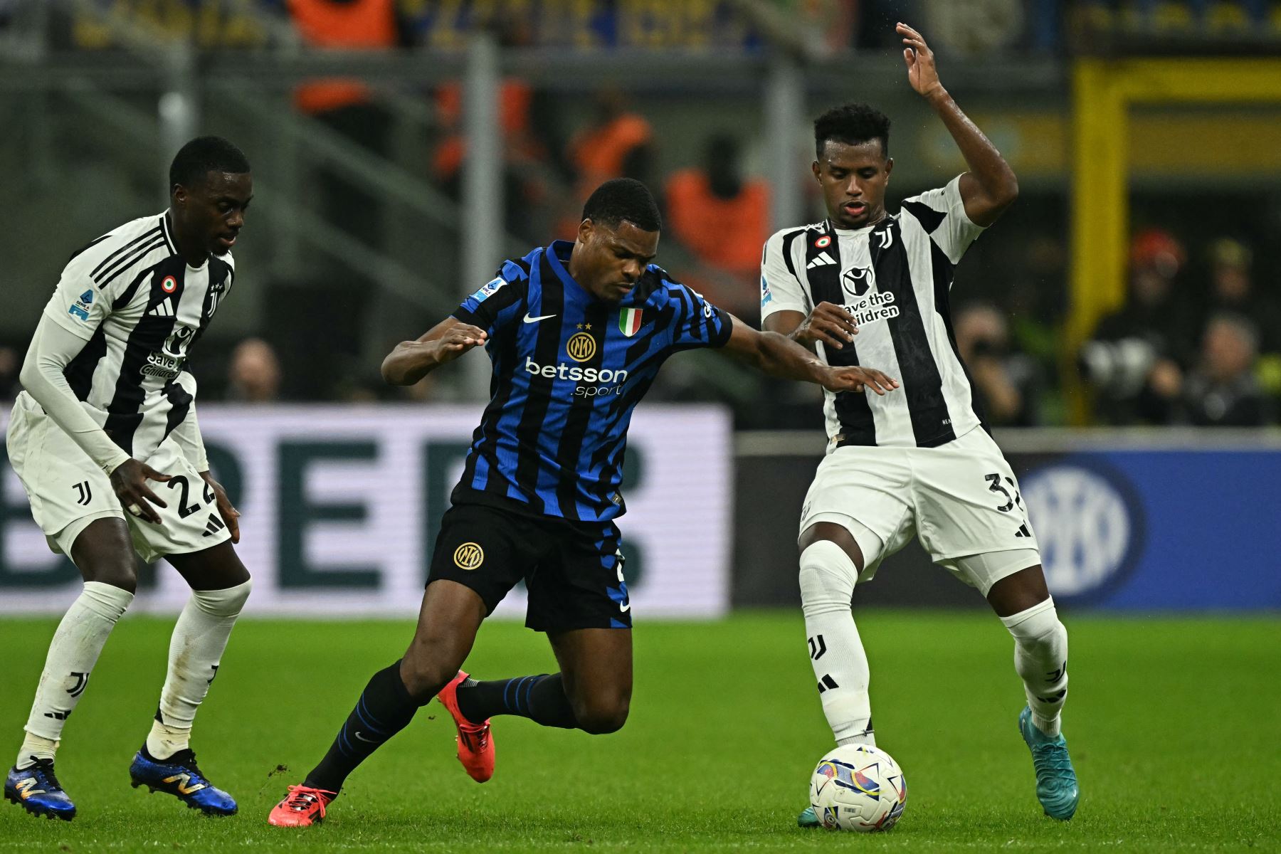 El defensor holandés del Inter de Milán Denzel Dumfries lucha por el balón con el delantero estadounidense de la Juventus Tim Weah y el defensor colombiano de la Juventus  Juan Cabal durante el partido de fútbol de la Serie A italiana entre el Inter de Milán y la Juventus. AFP