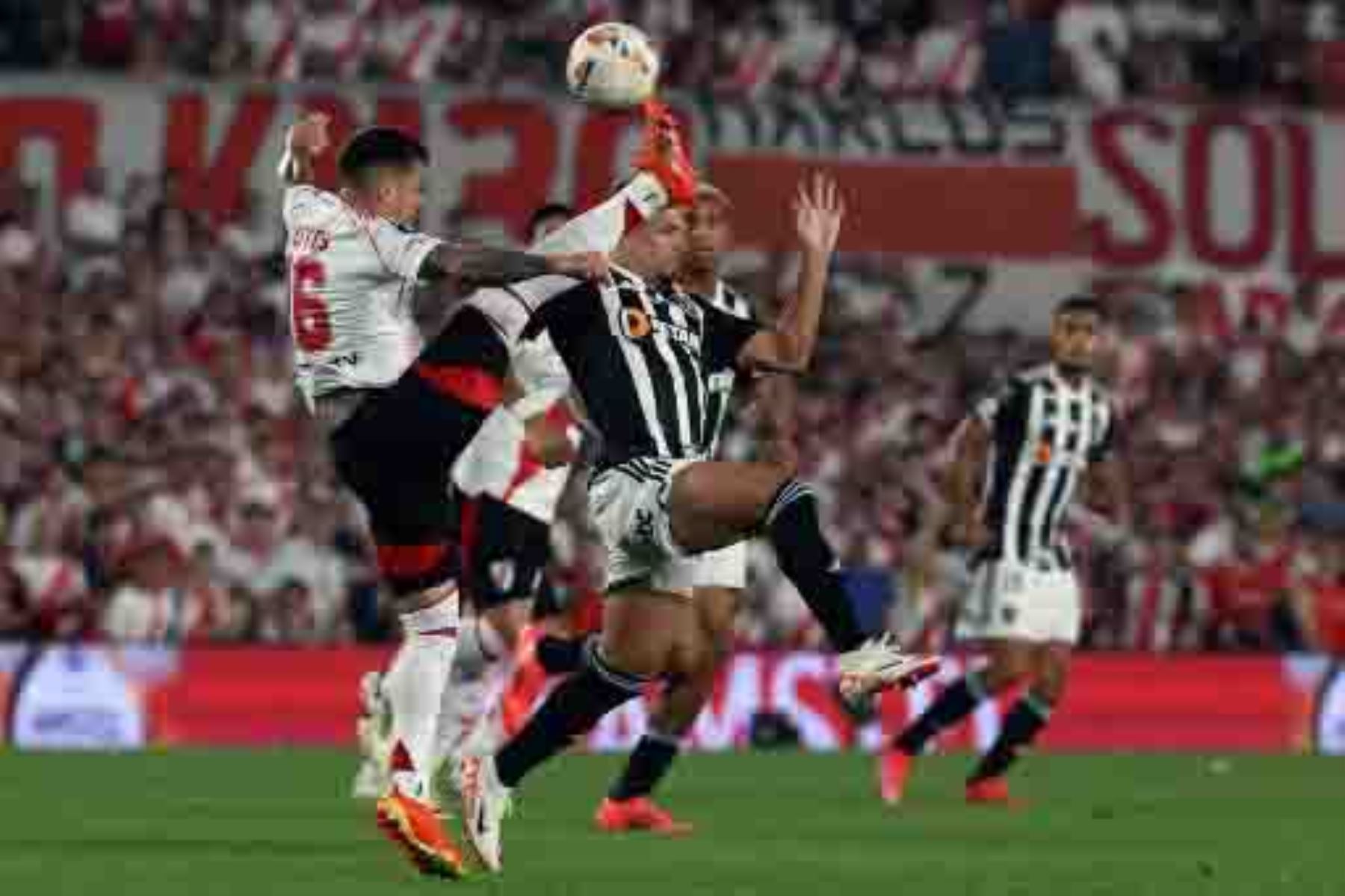 El defensor de River Plate Fabricio Bustos y el delantero del Atlético Mineiro  Paulinho luchan por el balón durante el partido de fútbol de vuelta de la semifinal de la Copa Libertadores entre River Plate de Argentina y el Atlético Mineiro de Brasil en el estadio Monumental de Buenos Aires. Foto: AFP