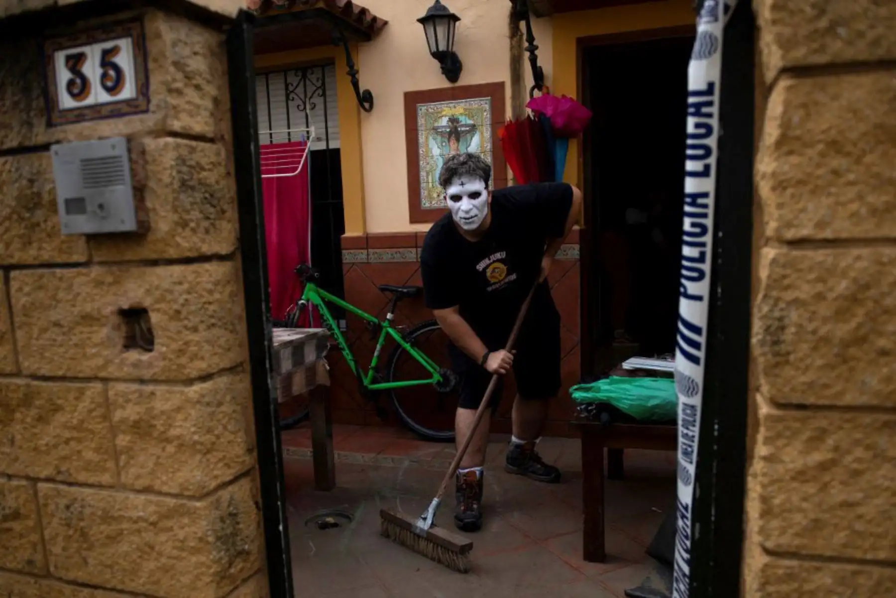 Un hombre con una máscara de Halloween limpia su casa inundada en Jerez de la Frontera, cerca de Cádiz, el 31 de octubre de 2024, después de que una fuerte lluvia azotara el sur de España. Foto: AFP