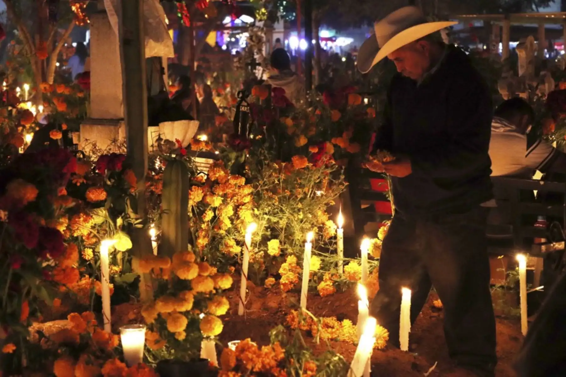 Decenas de personas encienden velas y colocan ofrendas sobre las tumbas de sus seres queridos durante la celebración del Día de Muertos en el cementerio del pueblo de Santa María Atzompa, estado de Oaxaca, México, el 31 de octubre de 2024. Foto: AFP