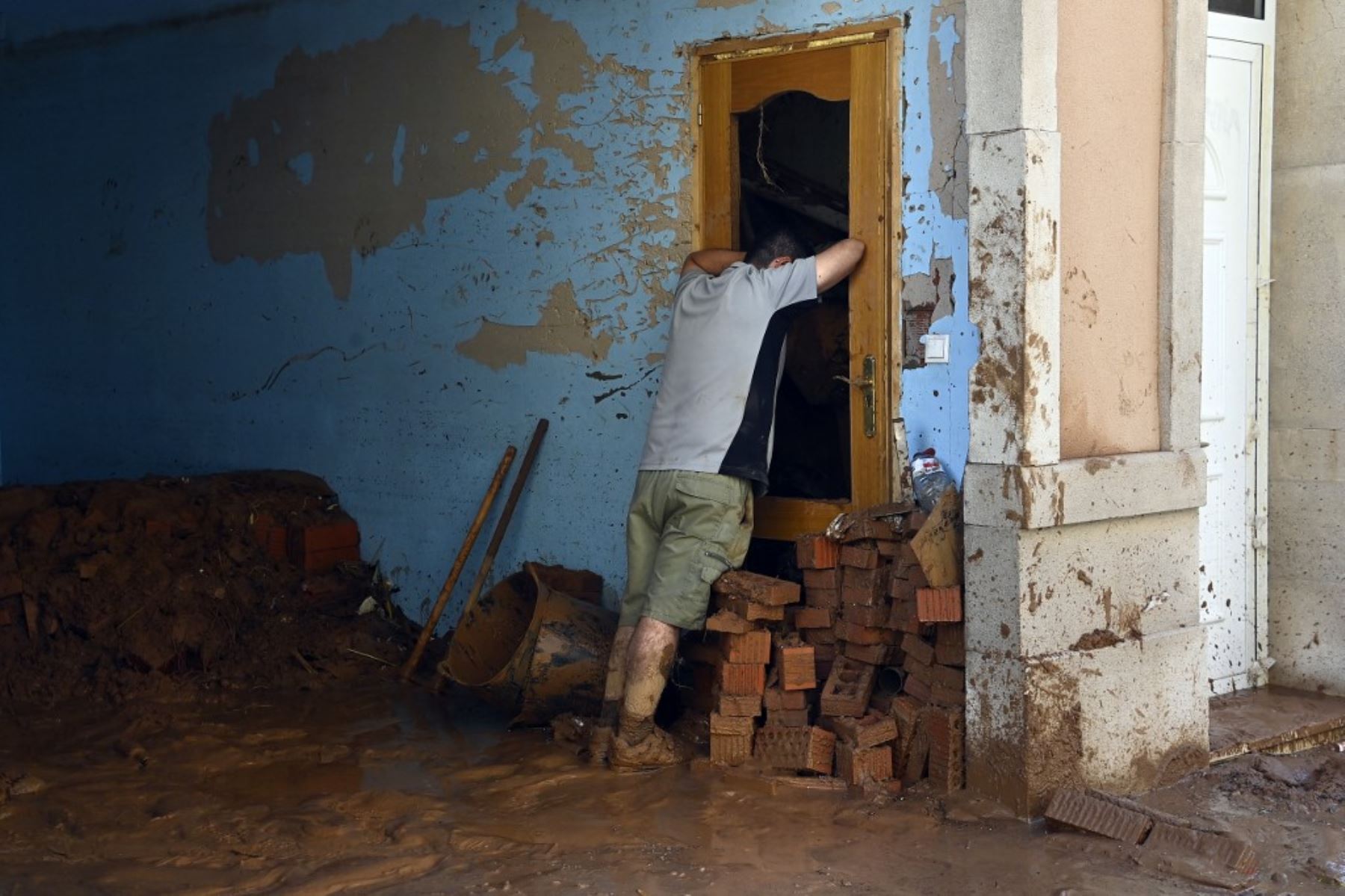 Un hombre se apoya en una puerta rota para tomar un respiro mientras limpia los interiores de un inmueble el 1 de noviembre de 2024, tras los devastadores efectos de las inundaciones en la ciudad de Paiporta, en la región de Valencia, al este de España. Foto: AFP