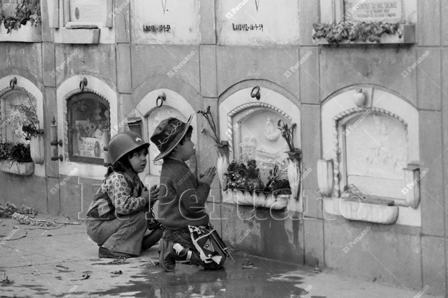 Lima - 1 noviembre 1974 / Dos niños rezan frente a la tumba de un familiar en el cementerio El Ángel en el Día de Todos los Santos. Foto: Archivo Histórico de El Peruano / Raúl Sagástegui