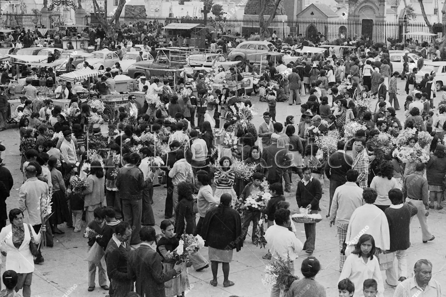 Lima - 1 noviembre 1976 / Vendedores de flores y puestos ambulantes en los exteriores del cementerio El Ángel en el Día de Todos los Santos.  Foto: Archivo Histórico de El Peruano / Rómulo Luján