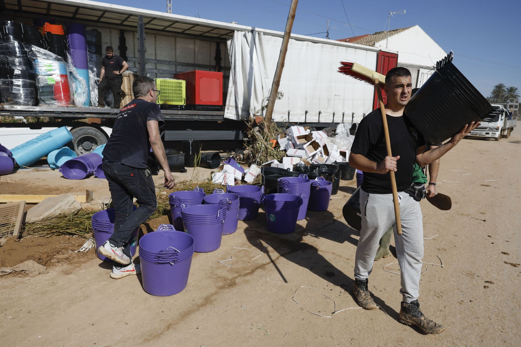 Uno de los voluntarios recoge material para colaborar en las labores de limpieza de la localidad de Paiporta este sábado tras el paso de la DANA. 
Foto: EFE