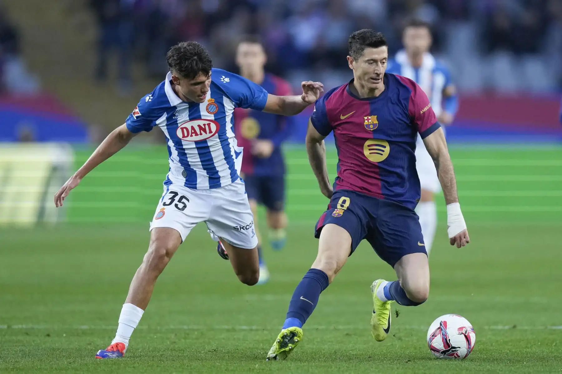 El atacante polaco del FC Barcelona Robert Lewandowski y el centrocampista del Espanyol Rafael Bauza, en acción durante el partido de LaLiga que enfrenta al FC Barcelona contra el Espanyol . Foto: EFE