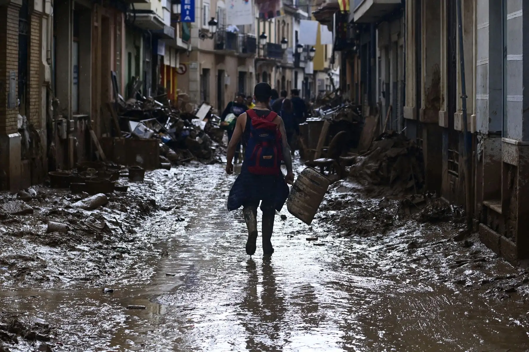 Un voluntario camina por una calle embarrada cuando sale de Paiporta, en la región de Valencia, este de España,  tras las devastadoras inundaciones mortales. El número de muertos por las peores inundaciones sufridas en España en una generación ha aumentado a 217, dijeron hoy los rescatistas. AFP