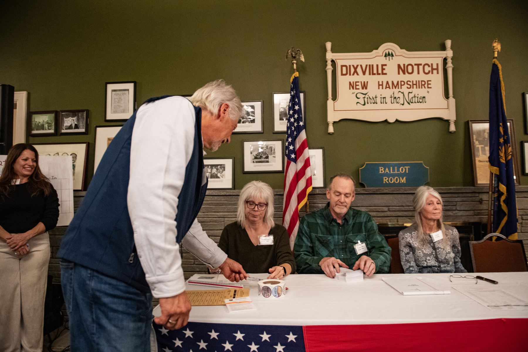 Un residente de Dixville Notch muestra su identificación mientras se registra para emitir su voto en las elecciones estadounidenses a medianoche en el salón de la Casa Tillotson en el Balsams Grand Resort, marcando los primeros votos en las elecciones estadounidenses, en Dixville Notch, Nueva Hampshire. Foto: AFP