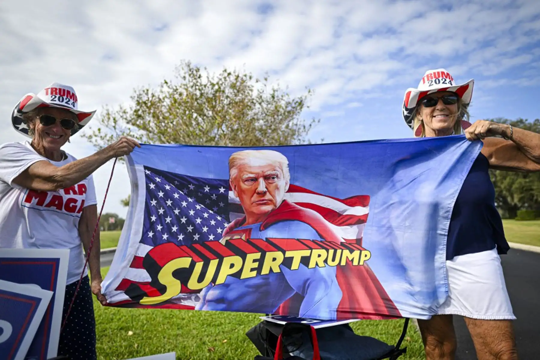 Simpatizantes del expresidente estadounidense y candidato presidencial republicano Donald Trump sostienen una bandera frente a un colegio electoral, el día de las elecciones, en The Villages, Florida.
Foto: AFP