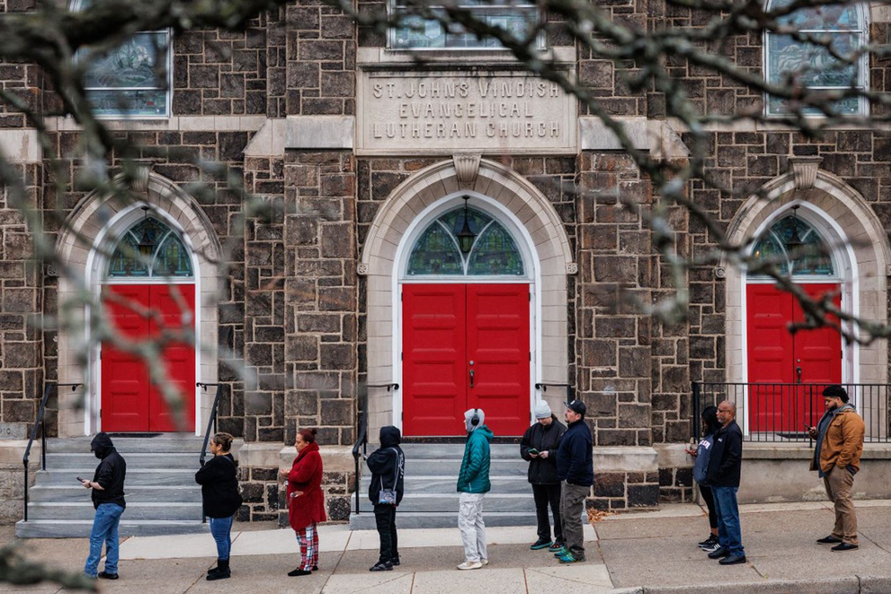 Los votantes hacen fila afuera de un colegio electoral en la Iglesia Evangélica Luterana St. John