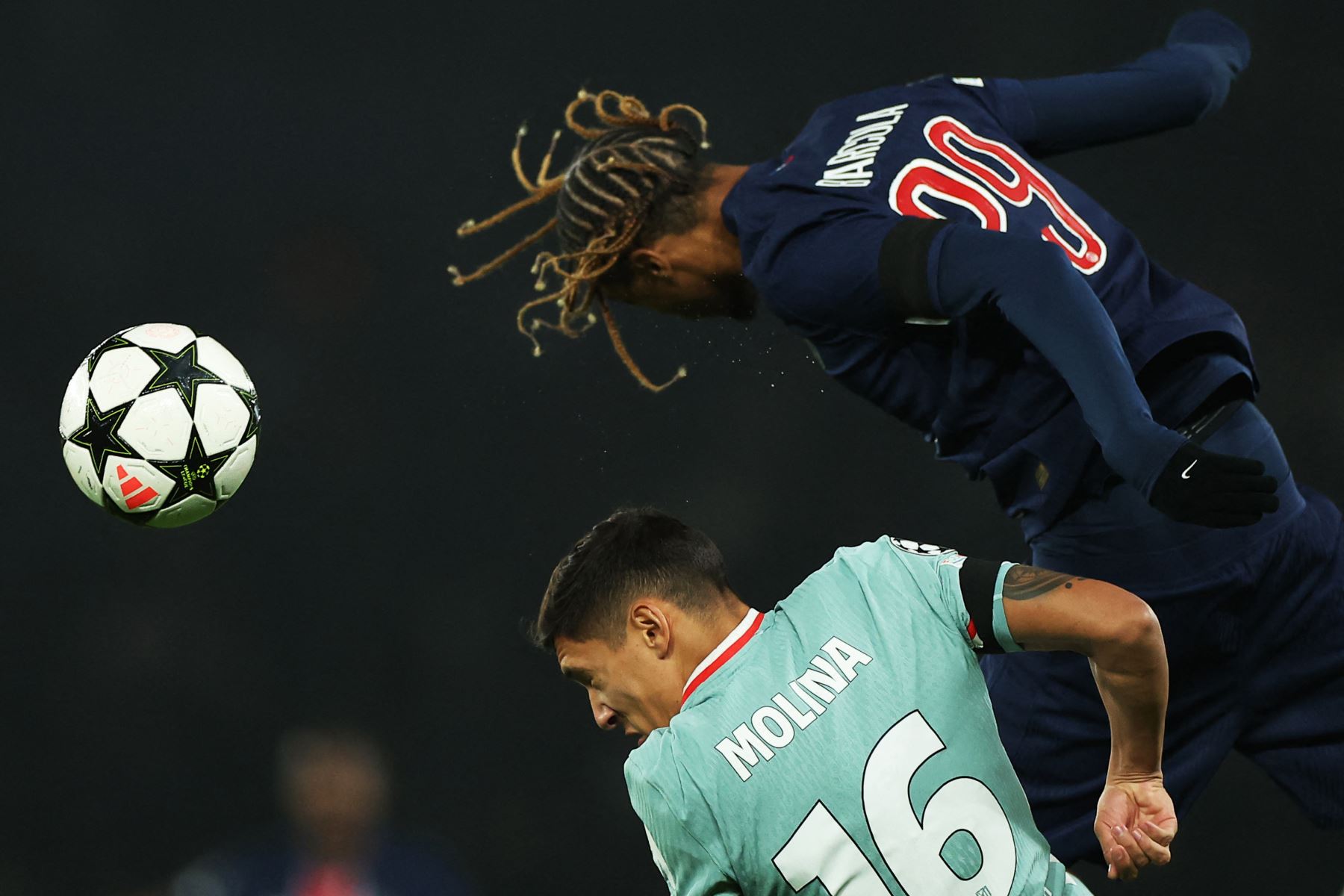 El delantero francés del Paris Saint-Germain #29 Bradley Barcola (R) encabeza el balón pasando por el defensor argentino del Atlético de Madrid #16 Nahuel Molina Lucero durante la Liga de Campeones de la UEFA, fase de Liga - Jornada 4, partido de fútbol entre el Paris Saint-Germain (PSG) y el Atlético Madrid. AFP