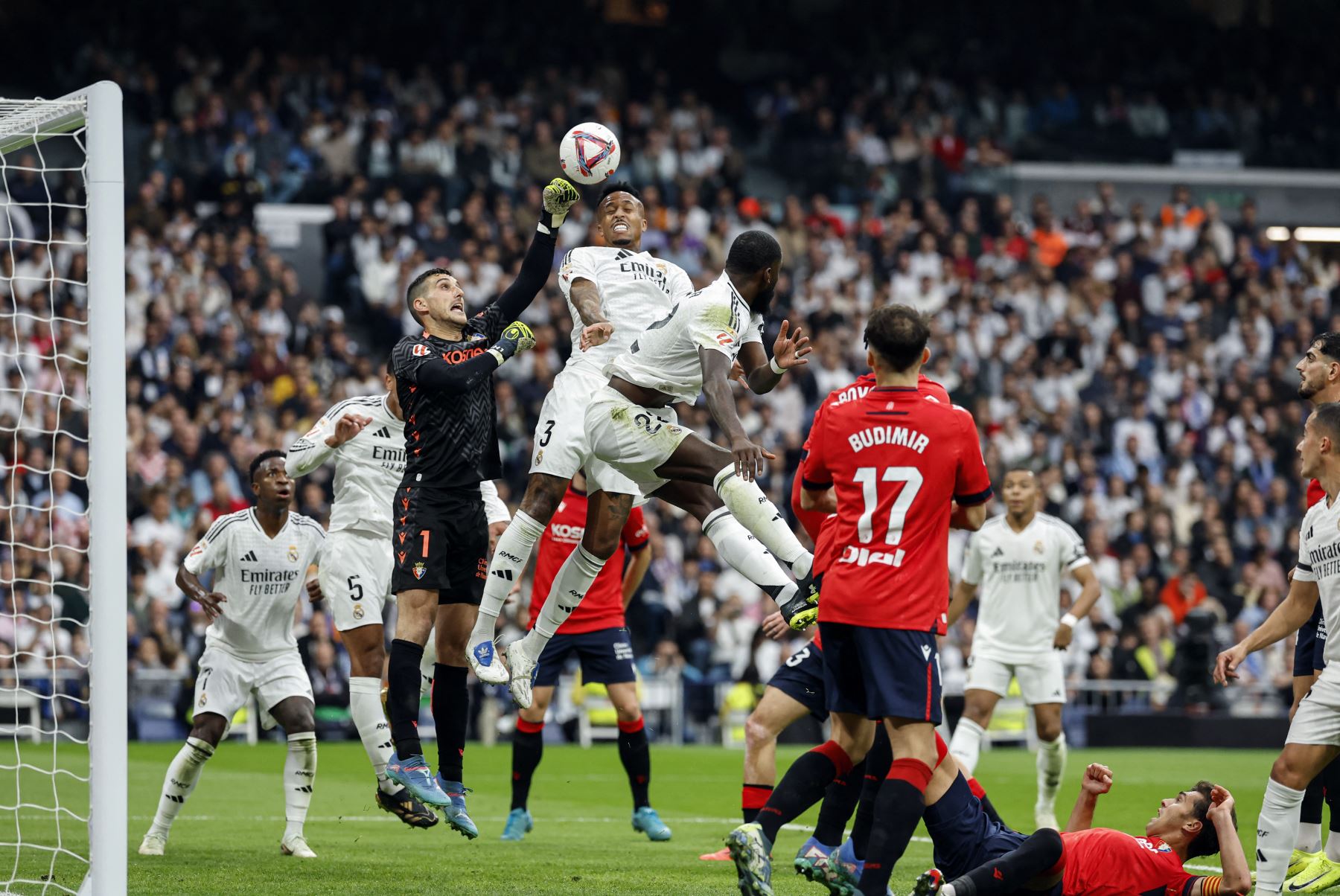 El defensor brasileño del Real Madrid  Eder Militao  es desafiado por el portero español de Osasuna  Sergio Herrera durante el partido de fútbol de la liga española entre el Real Madrid CF y el CA Osasuna. Foto: AFP