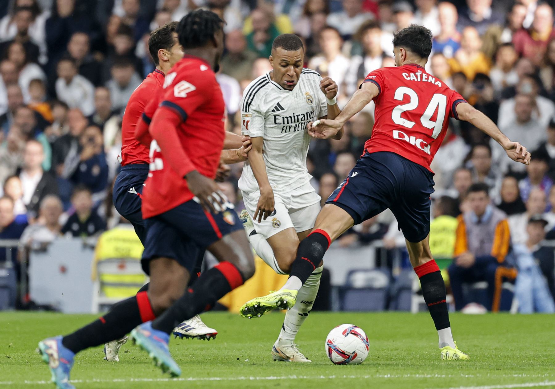 El delantero francés del Real Madrid  Kylian Mbappé  es desafiado por el defensor español de Osasuna  Catena durante el partido de fútbol de la liga española entre el Real Madrid CF y el CA Osasuna. AFP