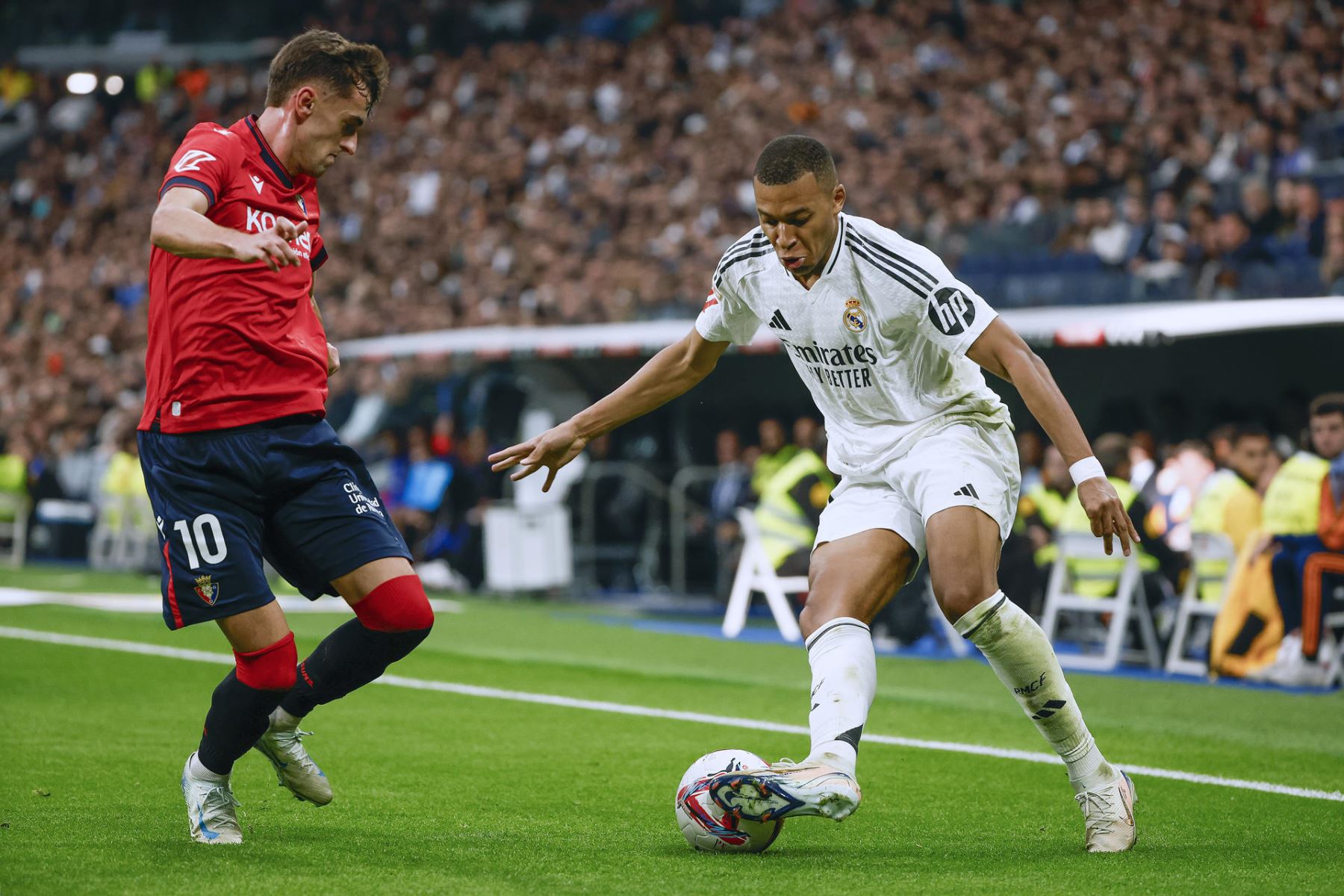 El delantero francés del Real Madrid Kylian Mbappé controla el balón ante Aimar Oroz, de Osasuna, durante el partido de la jornada 13 de LaLiga entre Real Madrid y Osasuna. EFE