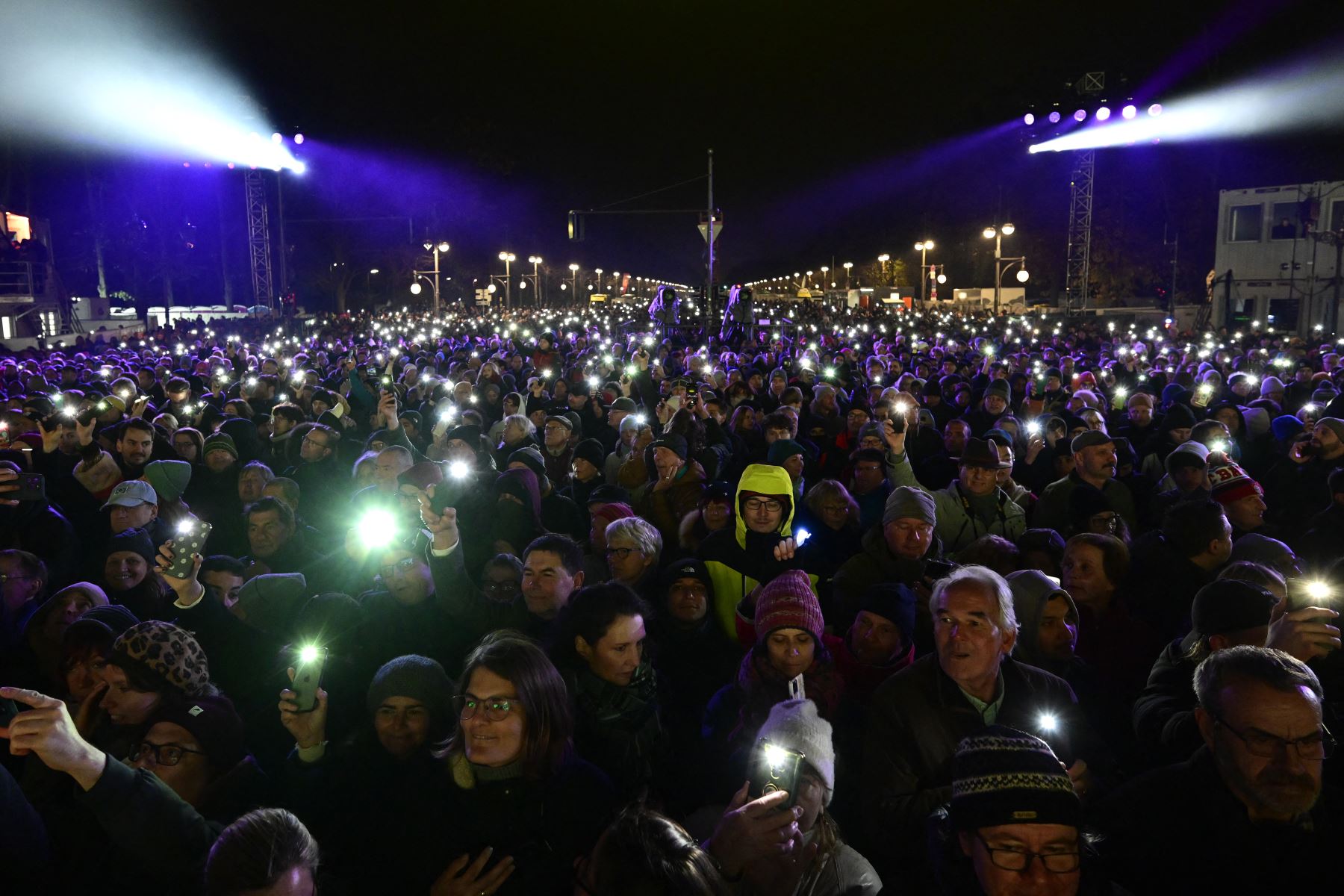 Los espectadores levantan las luces de sus teléfonos inteligentes al comienzo del concierto donde cientos de músicos tocan en el escenario durante el "Konzert für Freiheit"  con motivo del 35º aniversario de la caída del Muro de Berlín.
Foto: AFP