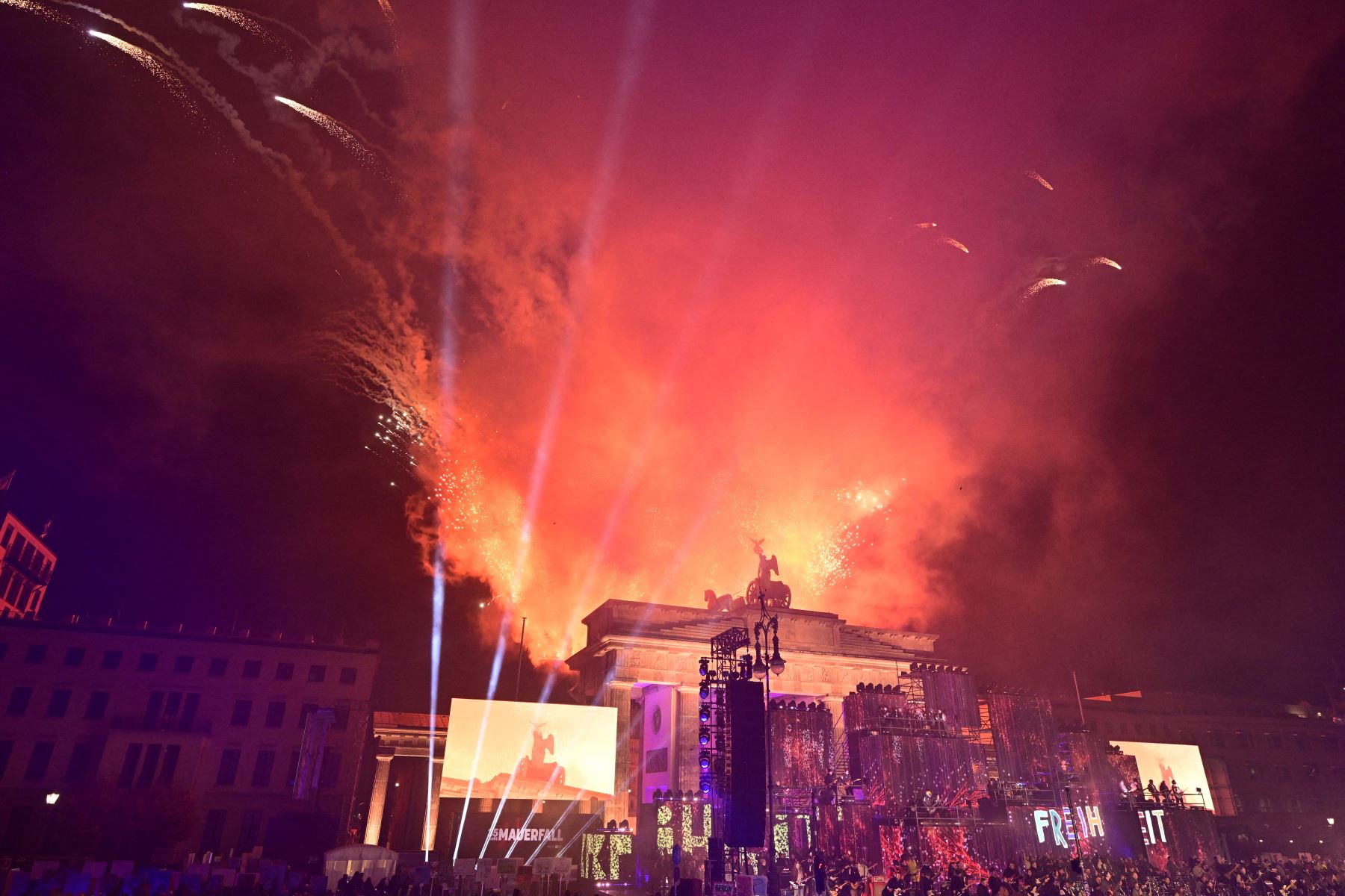 Los fuegos artificiales iluminan el cielo sobre la Puerta de Brandeburgo mientras los músicos tocan en el escenario durante el "Konzert für Freiheit" (concierto por la libertad) con motivo del 35º aniversario de la caída del Muro de Berlín.
Foto: AFP