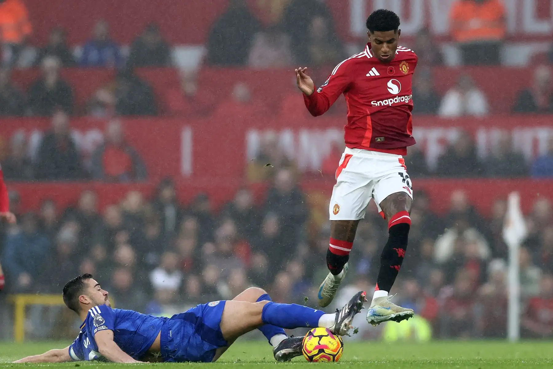 El delantero inglés del Manchester United Marcus Rashford salta sobre el centrocampista inglés del Leicester City  Harry Winks durante el partido de fútbol de la Premier League inglesa entre el Manchester United y el Leicester City. AFP