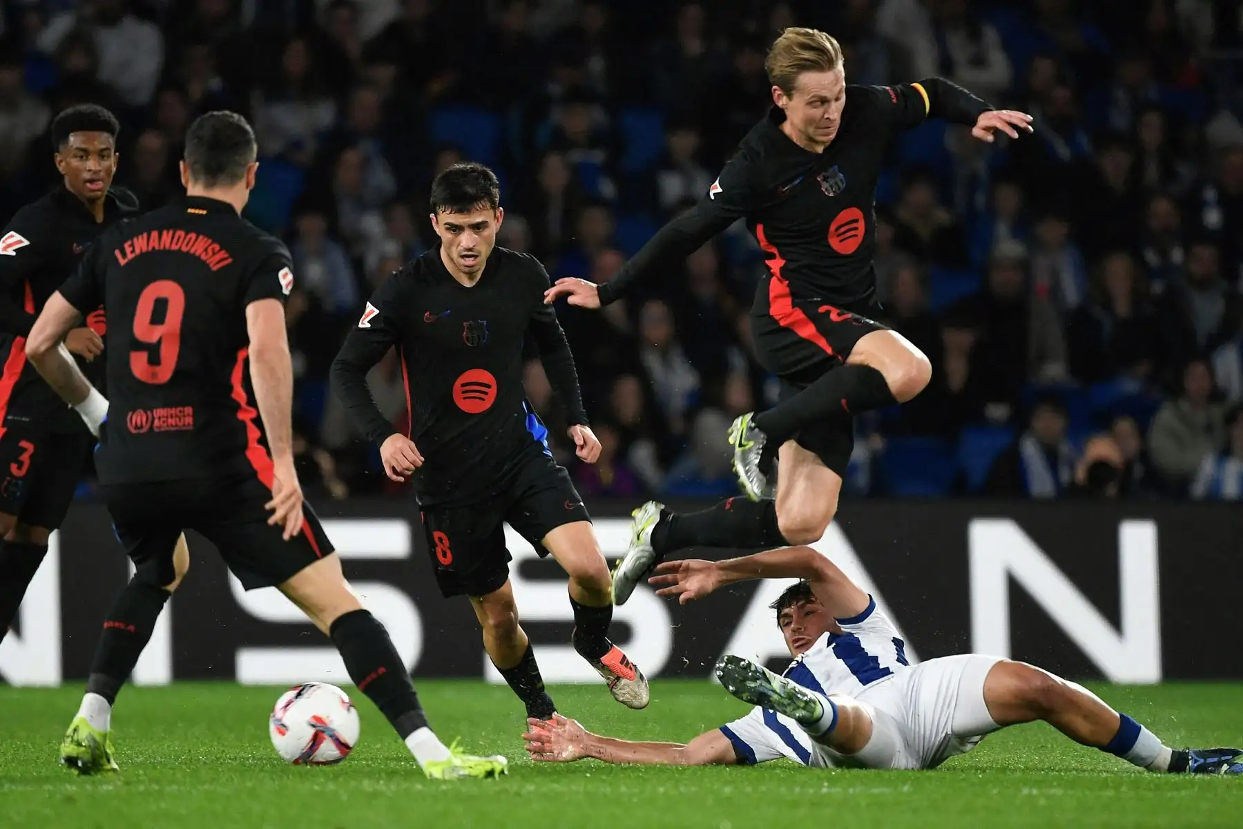 El defensor venezolano de la Real Sociedad, Jon Aramburu  compite por el balón mientras el mediocampista holandés del Barcelona, Frenkie De Jong  salta y el delantero polaco del Barcelona , Robert Lewandowski mira durante el partido de fútbol de la liga española entre el Real Sociedad y FC Barcelona en el estadio de Anoeta de San Sebastián .
Foto: AFP