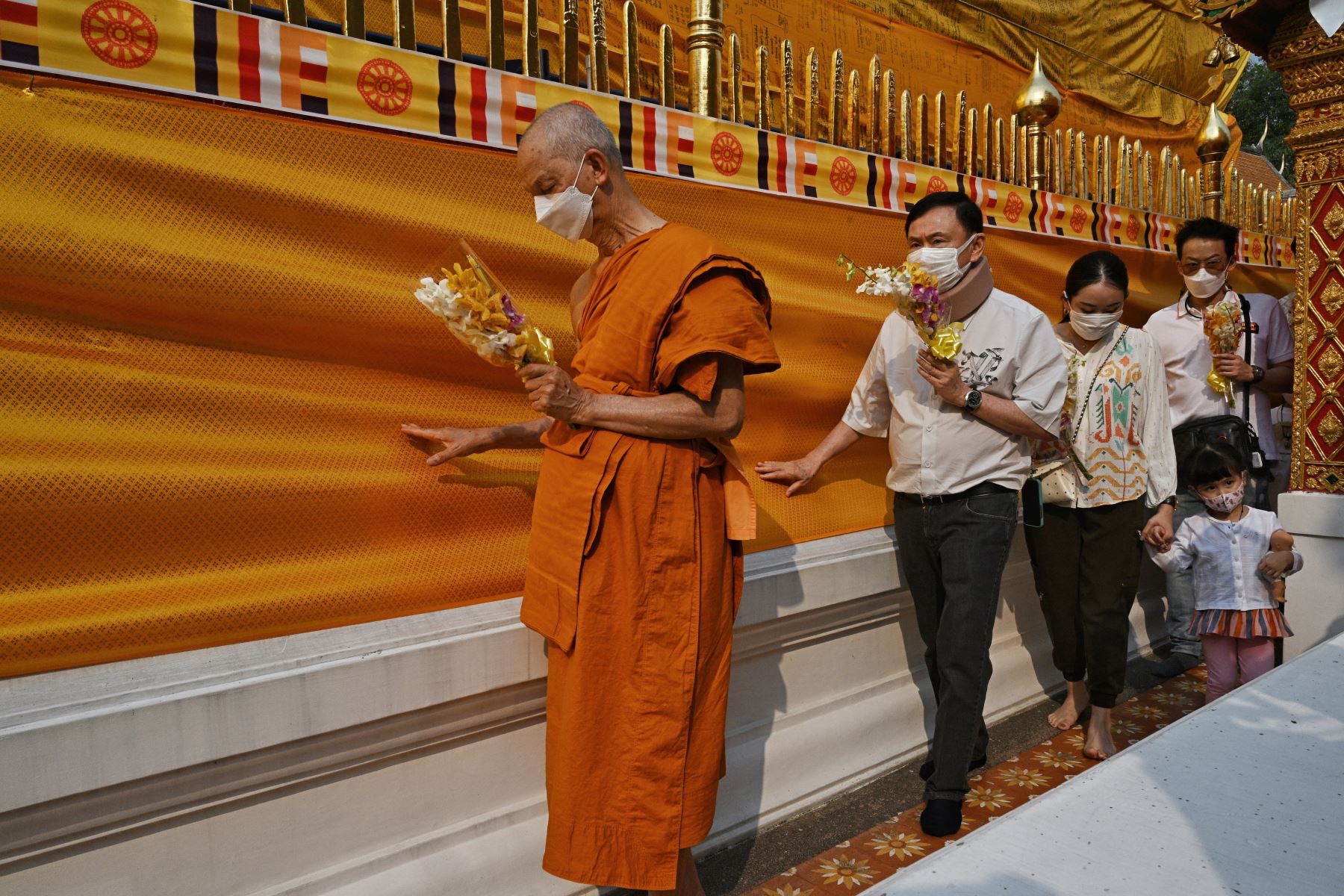 El ex primer ministro tailandés Thaksin Shinawatra  y su hija Paetongtarn Shinawatra caminan alrededor de la estupa del templo budista Wat Phra That Doi Suthep en Chiang Mai el 15 de marzo de 2024. AFP