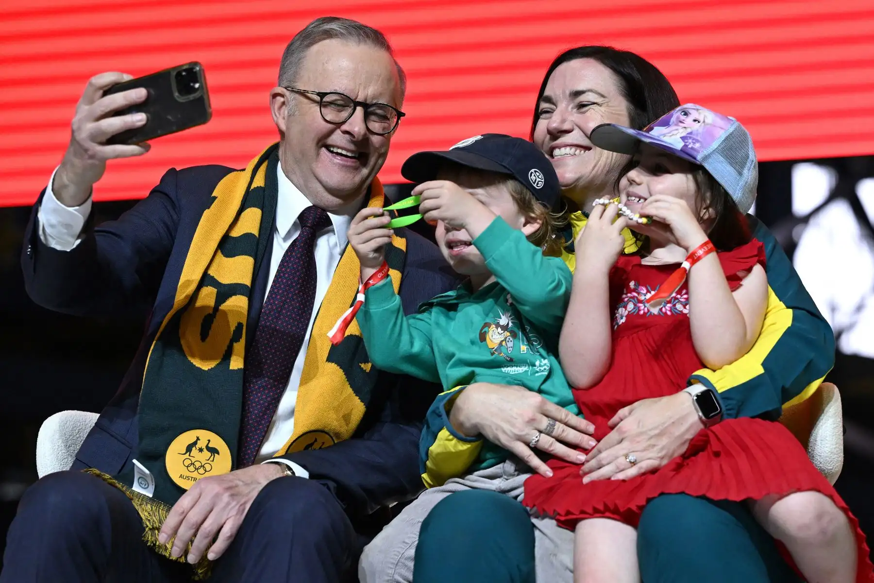 El primer ministro de Australia, Anthony Albanese  se toma selfies con la jefa de misión de Australia para París 2024, Anna Meares, y sus hijos durante un evento tras el regreso de los atletas australianos de los Juegos Olímpicos de París 2024 en el Aeropuerto Internacional de Sydney el 14 de agosto de 2024. AFP