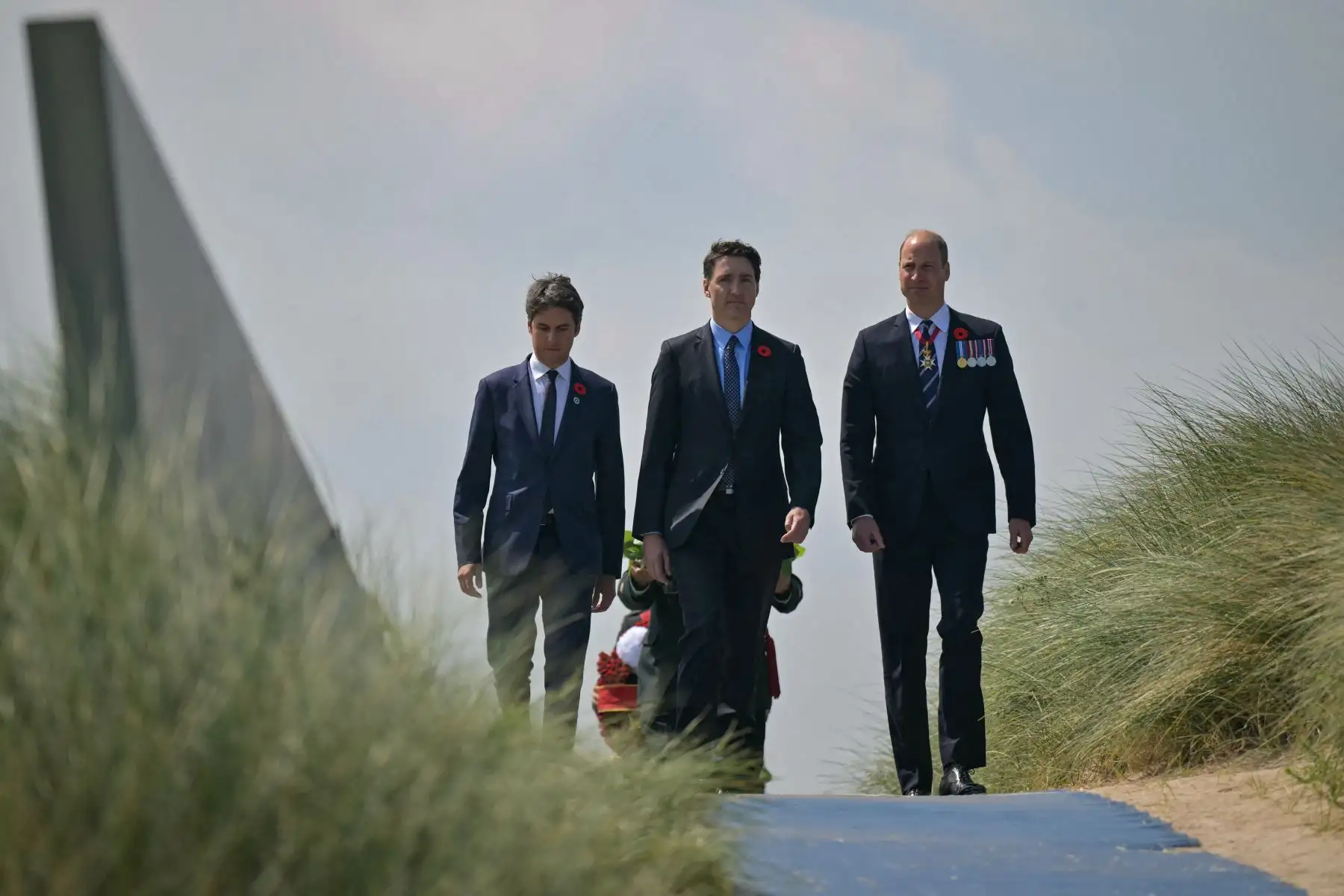 El Primer Ministro de Francia, Gabriel Attal, el Primer Ministro de Canadá, Justin Trudeau, y el Príncipe Guillermo de Gran Bretaña, el Príncipe de Gales, caminan por las dunas de arena cerca de la playa de Juno durante la ceremonia conmemorativa canadiense que marca el 80º aniversario de la Segunda Guerra Mundial "D- Day" Desembarcos aliados en Normandía, en el Juno Beach Center, cerca del pueblo de Courseulles-sur-Mer, en el noroeste de Francia, el 6 de junio de 2024. AFP