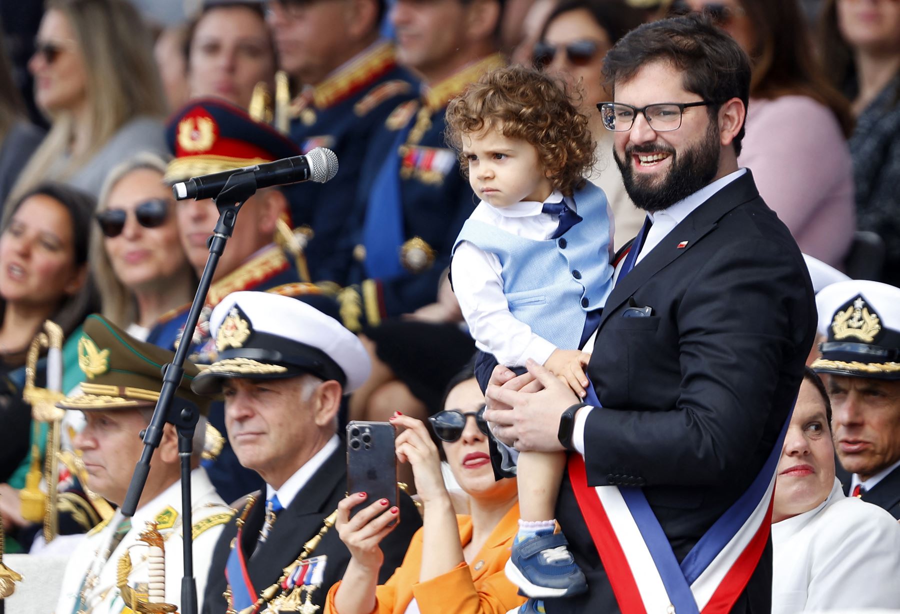 El presidente de Chile, Gabriel Boric, sostiene a su sobrino durante el desfile del Día de las Glorias del Ejército, parte de las celebraciones del aniversario de la independencia de Chile, en Santiago, el 19 de septiembre de 2024. AFP