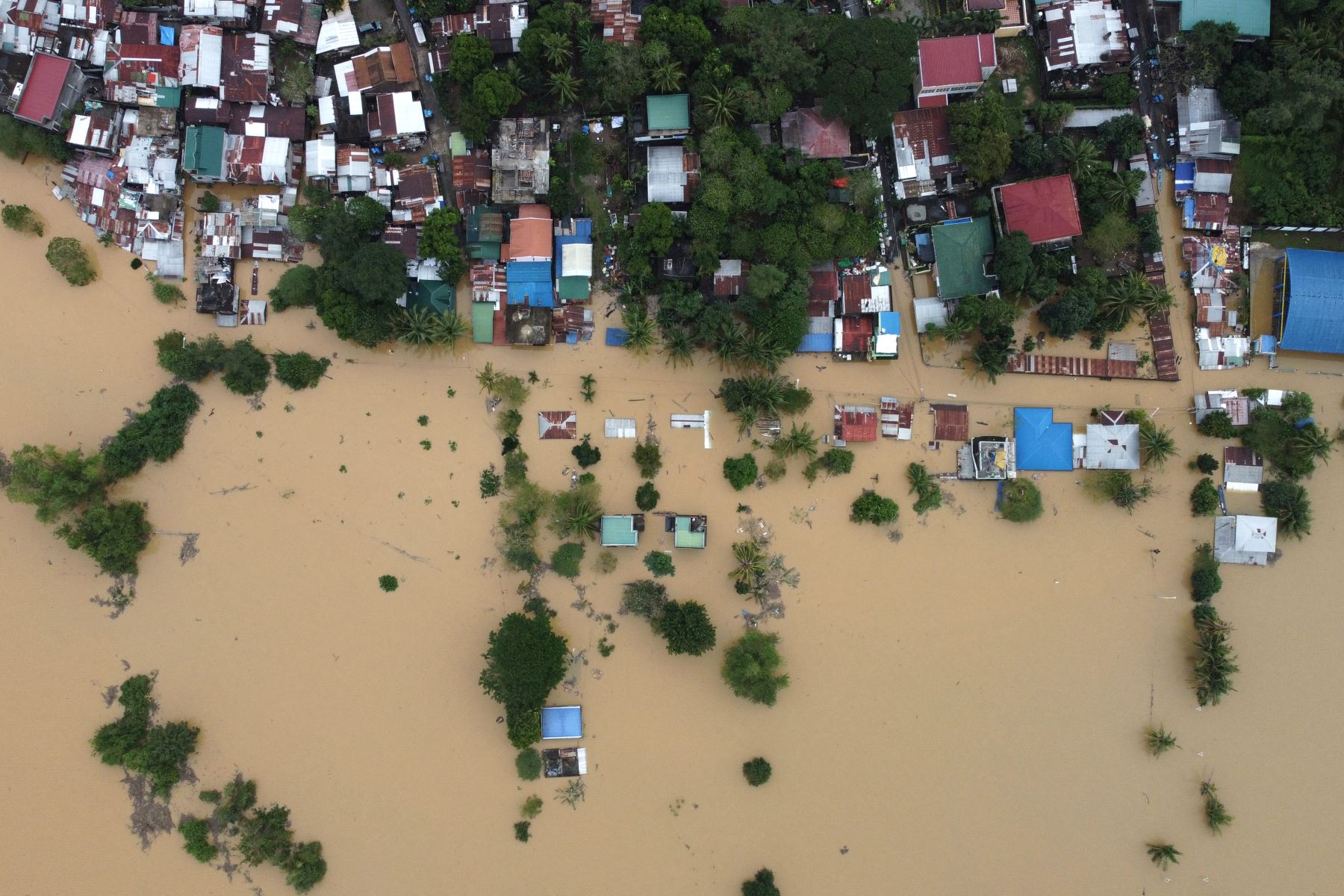 Una vista aérea muestra casas sumergidas en una aldea de Ilagan, provincia de Isabela, en Filipinas, el 18 de noviembre de 2024, debido a las fuertes lluvias continuas del súper tifón Man-yi. Los filipinos retiraron árboles caídos y repararon casas dañadas. Foto: AFP