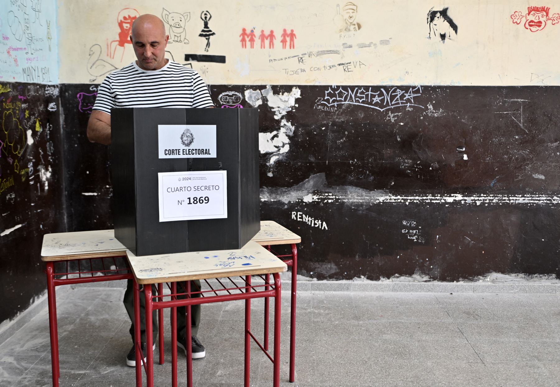 Un hombre deposita su voto durante la segunda vuelta presidencial en Montevideo. AFP