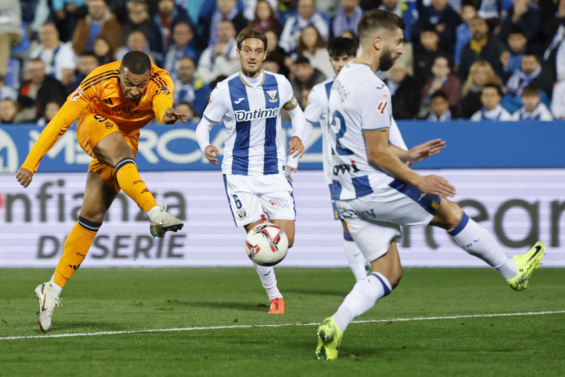 El delantero francés del Real Madrid  Kylian Mbappé dispara durante el partido de fútbol de la liga española entre el Club Deportivo Leganés SAD y el Real Madrid CF en el Estadio Municipal Butarque de Leganés. Foto: AFP