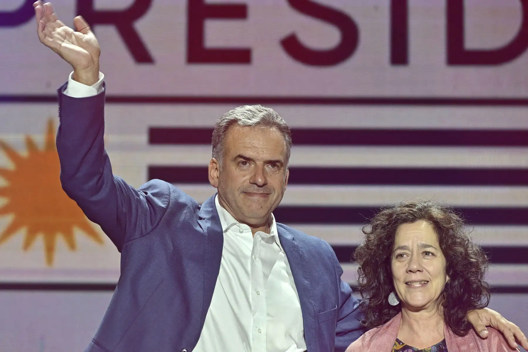 El presidente electo de Uruguay, Yamandú Orsi, de la coalición Frente Amplio, saluda junto a su esposa Laura Alonsoperez durante su discurso de victoria después de la segunda vuelta presidencial en Montevideo.
Foto: AFP