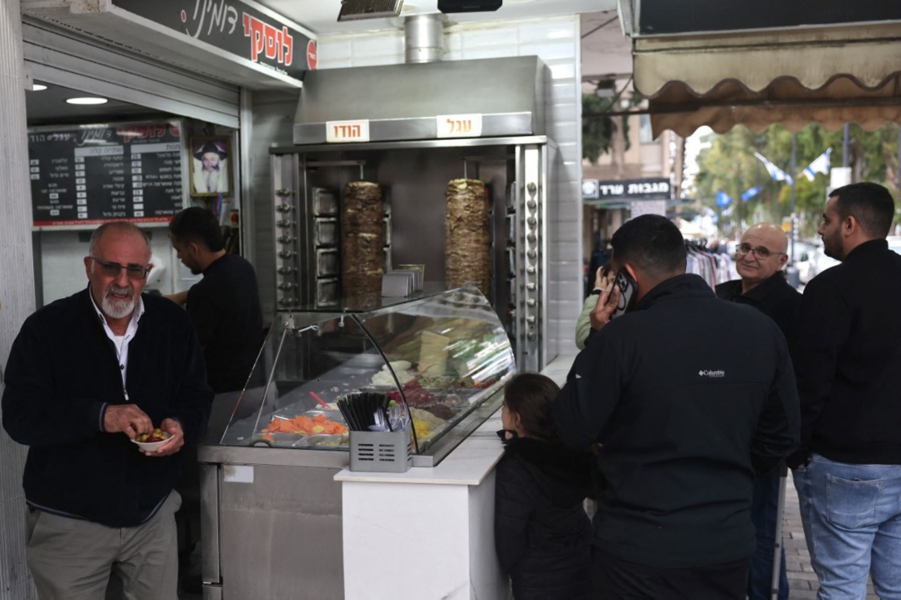 La gente espera su comida en un restaurante en Nahariya, en el norte de Israel, el 27 de noviembre de 2024, después de que entrara en vigor un alto el fuego entre Israel y Hezbolá.  Foto: AFP