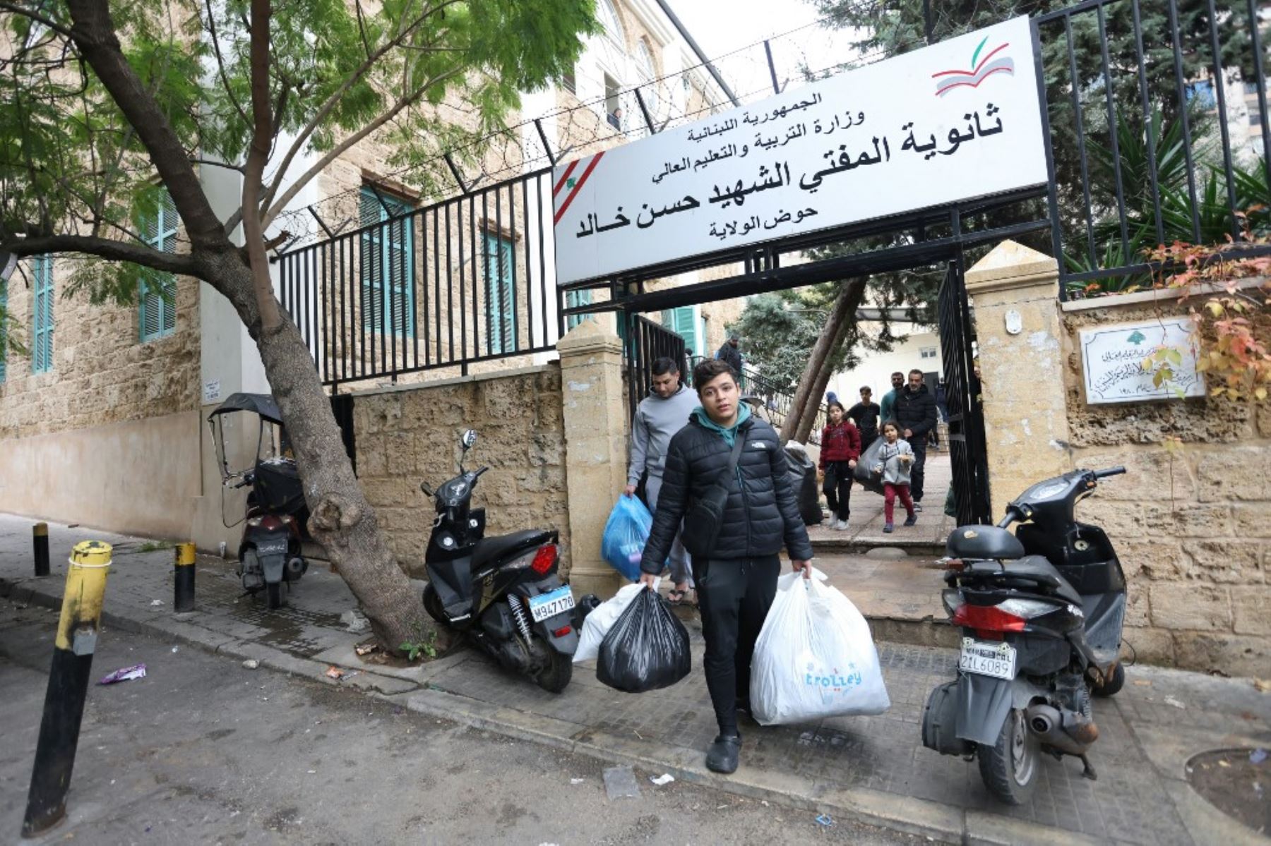 Las personas desplazadas cargan sus pertenencias al salir de una escuela convertida en refugio en Beirut el 27 de noviembre de 2024, mientras la gente regresa a sus hogares después de que entrara en vigor un alto el fuego entre Israel y Hezbolá. Se estableció un alto el fuego entre Israel y Hezbollah en el Líbano después de más de un año de combates que han matado a miles de personas. Foto: AFP