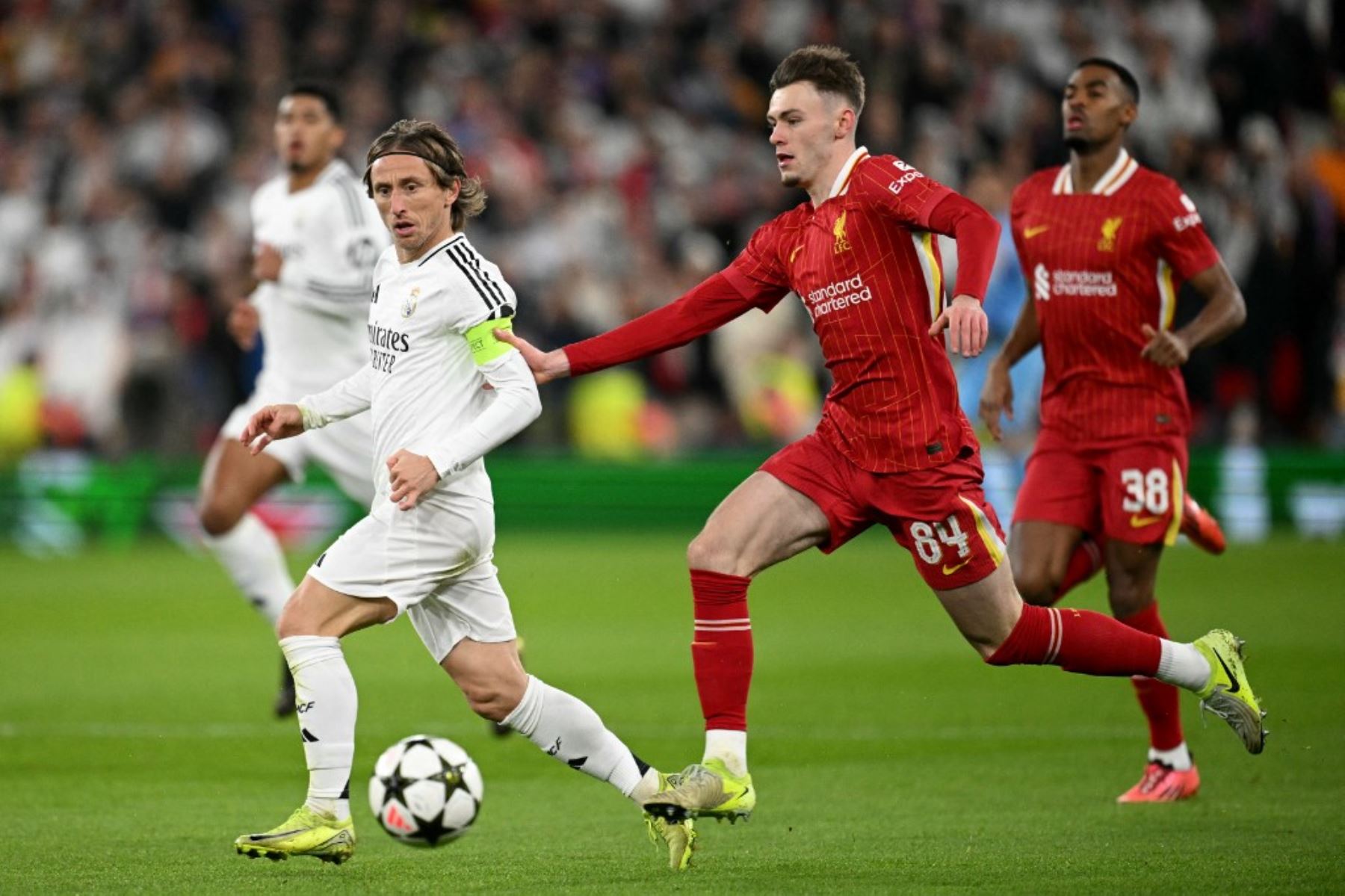 El defensor norirlandés del Liverpool  Conor Bradley compite por el balón con el centrocampista croata del Real Madrid Luka Modric durante el partido de fútbol de la Liga de Campeones de la UEFA entre Liverpool y Real Madrid. AFP