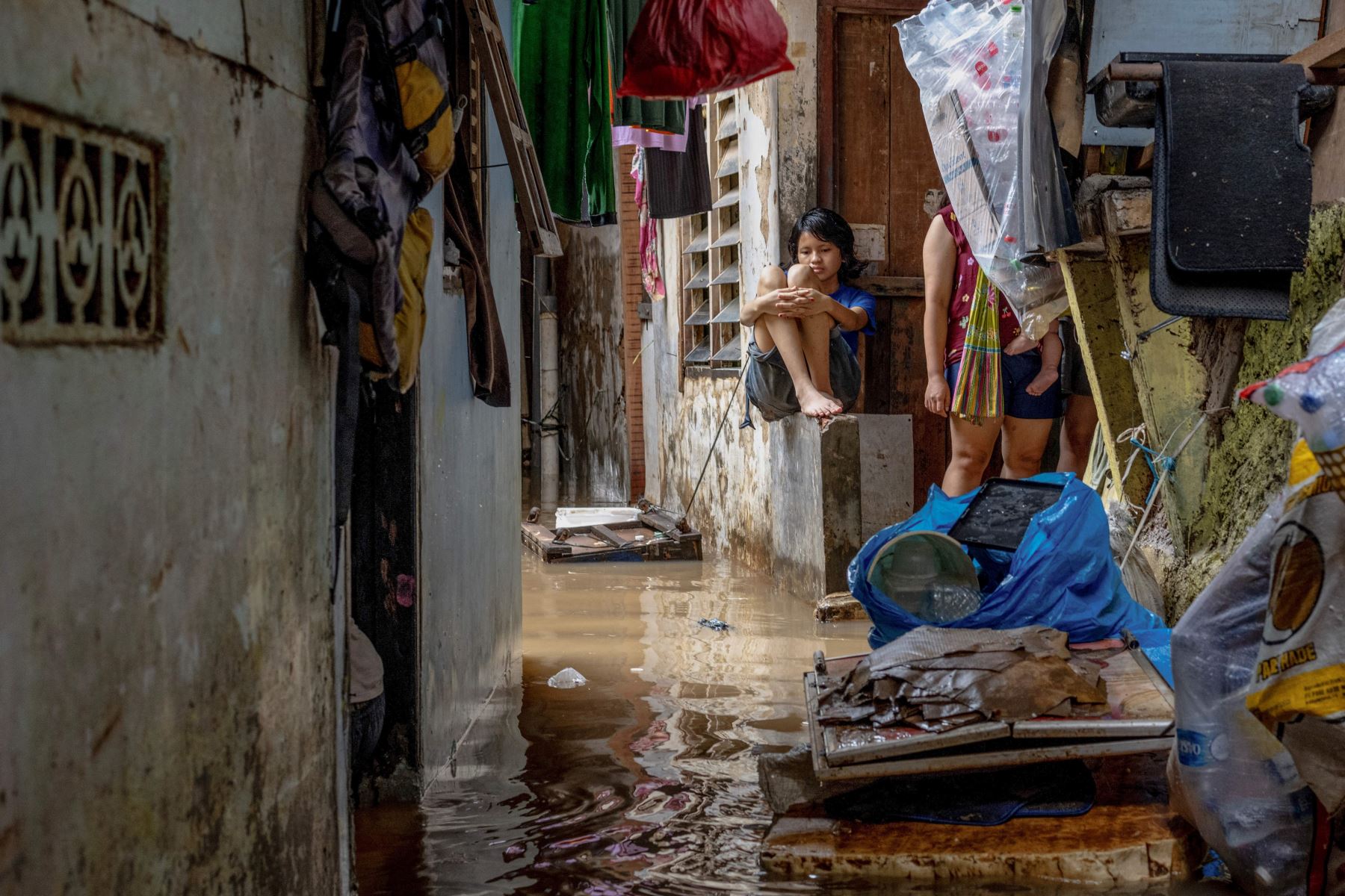 Una mujer observa las inundaciones resultantes del desbordamiento de un río después de fuertes lluvias en Yakarta. AFP