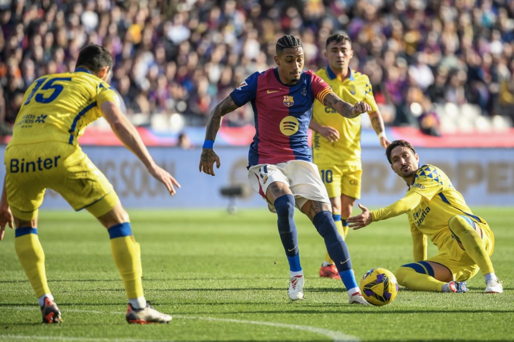 El delantero brasileño del Barcelona Raphinha (C) controla el balón desafiado por el defensor escocés de Las Palmas Scott McKenna (L) durante el partido de fútbol de la liga española entre el FC Barcelona y la UD Las Palmas en la Estadi Olimpic Lluis Companys en Barcelona el 30 de noviembre de 2024. Foto: AFP