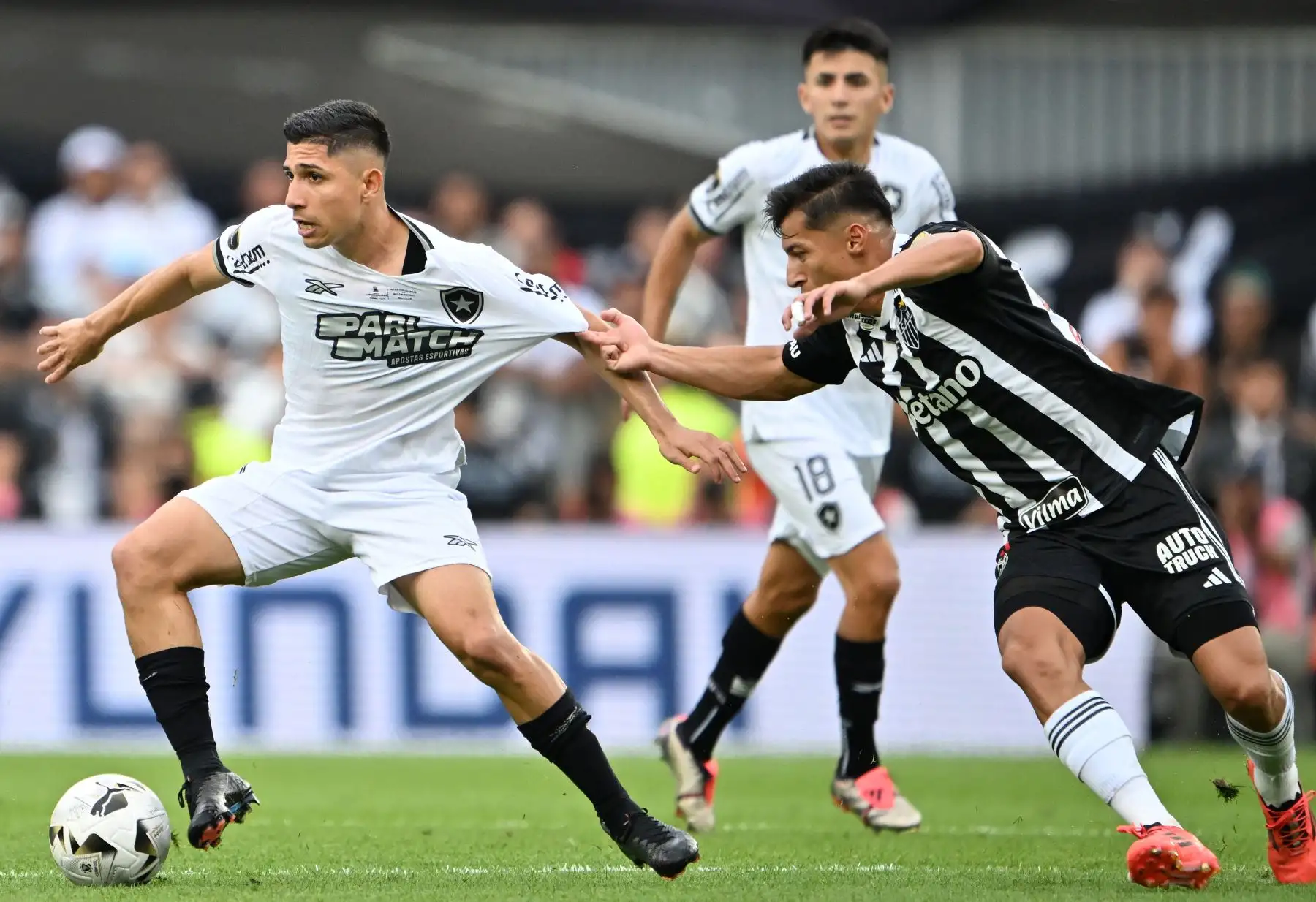 El delantero venezolano de Botafogo Jefferson Savarino y el mediocampista ecuatoriano  del Atlético Mineiro Alan Franco luchan por el balón durante el partido final de la Copa Libertadores entre los equipos brasileños Atlético Mineiro y Botafogo en el Estadio Mas Monumental de Buenos Aires. Foto: ANDINA/AFP