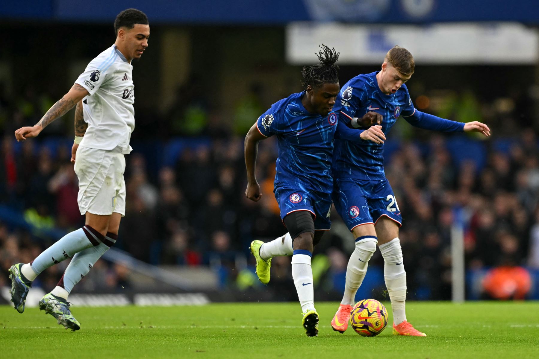 El centrocampista belga del Chelsea #45 Romeo Lavia y el centrocampista inglés del Chelsea #20 Cole Palmer (R) chocan durante el partido de fútbol de la Premier League inglesa entre Chelsea y Aston Villa en Stamford Bridge en Londres el 1 de diciembre de 2024. (Foto de Glyn KIRK / AFP)