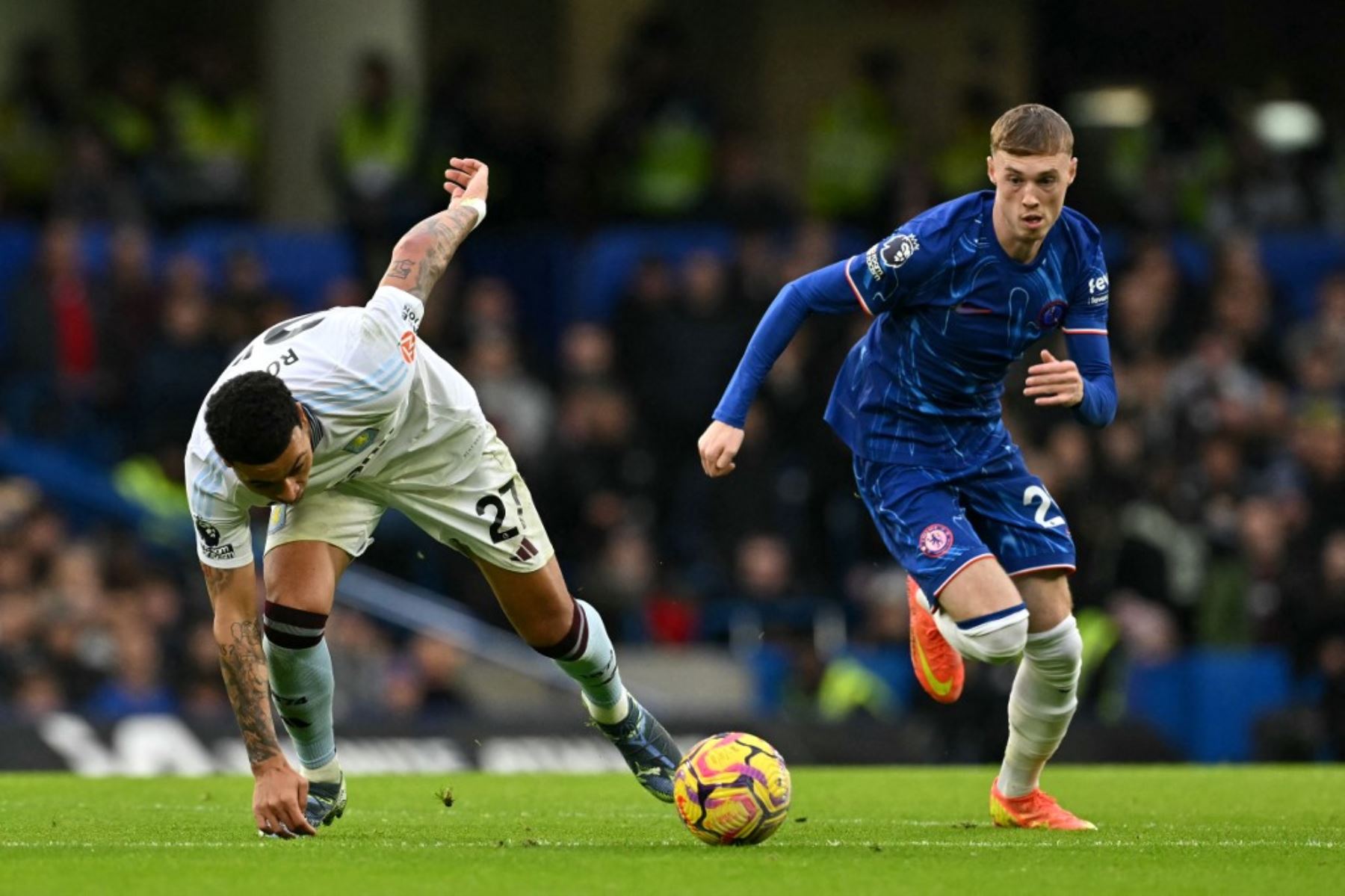 El centrocampista inglés del Chelsea #20, Cole Palmer, compite por el balón con el centrocampista inglés #27 del Aston Villa, Morgan Rogers, durante el partido de fútbol de la Premier League inglesa entre Chelsea y Aston Villa en Stamford Bridge en Londres el 1 de diciembre de 2024. (Foto de Glyn KIRK / AFP)