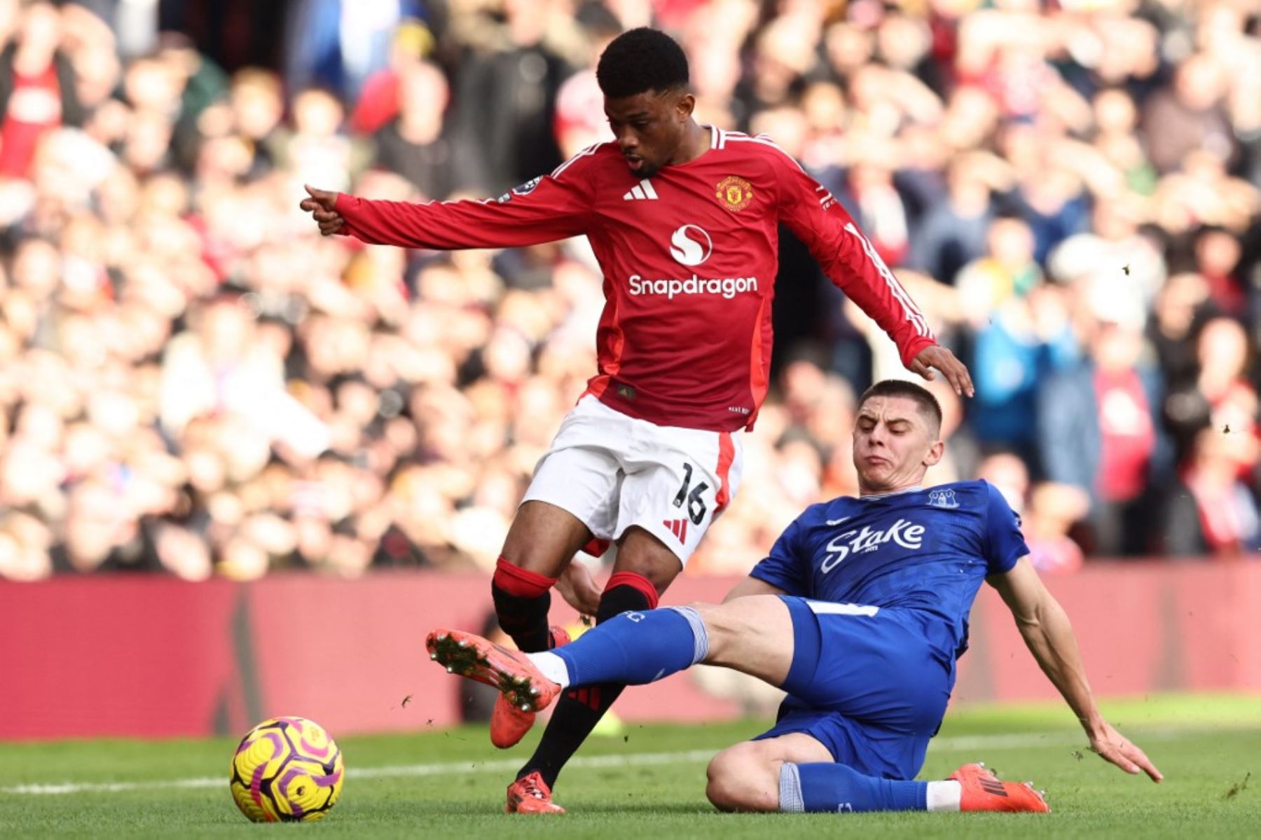 El centrocampista marfileño #16 del Manchester United, Amad Diallo (L), compite con el defensa ucraniano del Everton #19 Vitaliy Mykolenko (R) durante el partido de fútbol de la Premier League inglesa entre el Manchester United y el Everton en Old Trafford en Manchester, noroeste de Inglaterra, el 1 de diciembre de 2024. (Foto de Darren Staples / AFP)