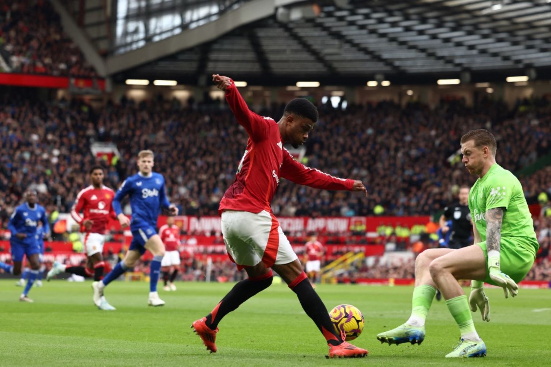 El centrocampista marfileño #16 del Manchester United, Amad Diallo (C), compite con el portero inglés del Everton #01 Jordan Pickford (R) durante el partido de fútbol de la Premier League inglesa entre el Manchester United y el Everton en Old Trafford en Manchester, noroeste de Inglaterra, el 1 de diciembre de 2024. (Foto de Darren Staples / AFP)