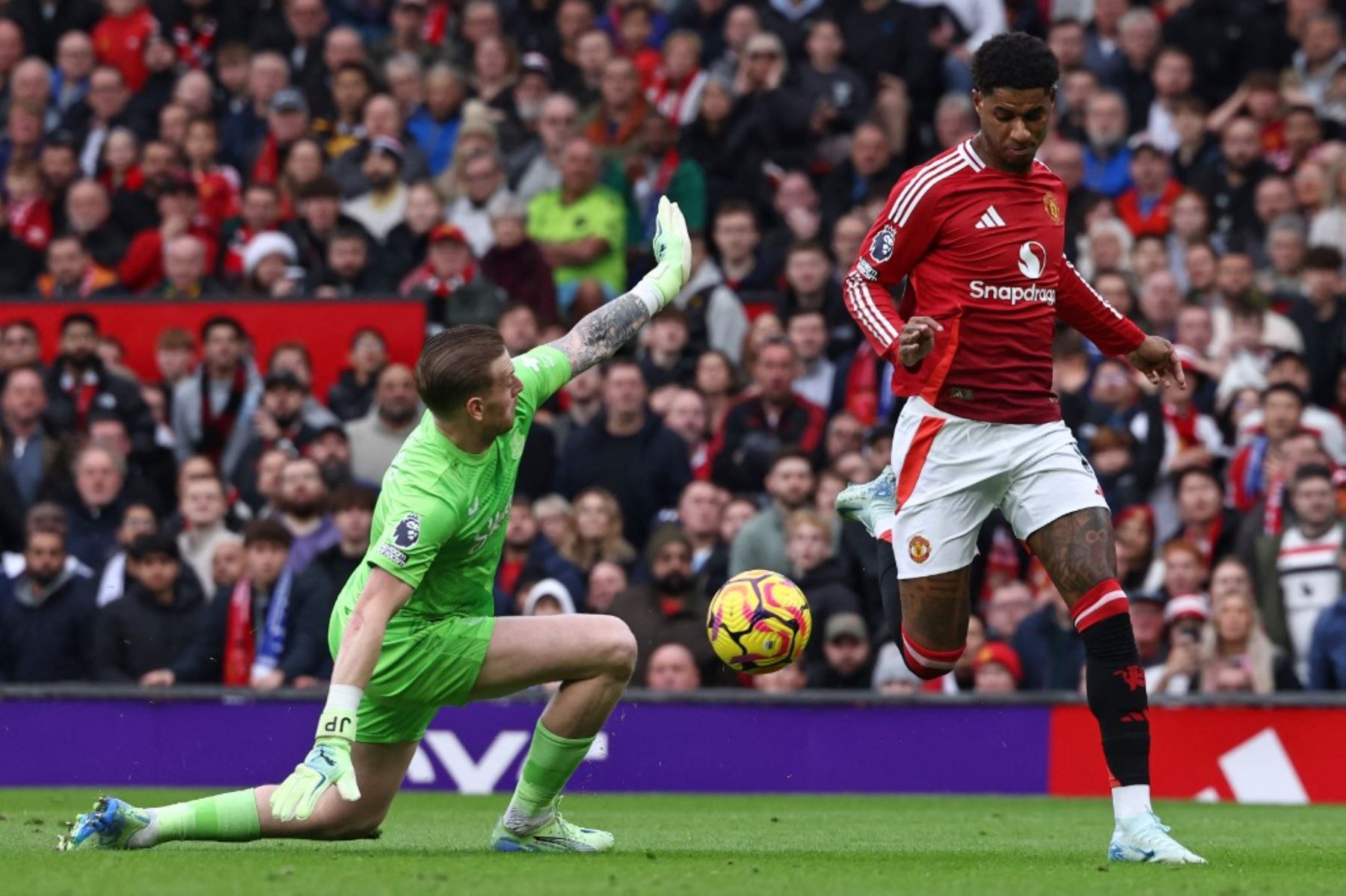 El delantero inglés #10 del Manchester United, Marcus Rashford (R), lleva el balón más allá del portero inglés del Everton #01, Jordan Pickford (L), pero está marcado fuera de juego durante el partido de fútbol de la Premier League inglesa entre el Manchester United y el Everton en Old Trafford en Manchester, noroeste de Inglaterra, el 1 de diciembre de 2024. (Foto de Darren Staples / AFP)