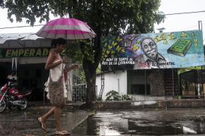 Una mujer camina por una calle de la ciudad natal del fallecido Premio Nobel de Literatura colombiano Gabriel García Márquez, Aracataca, en la provincia de Magdalena, Colombia. Foto: AFP